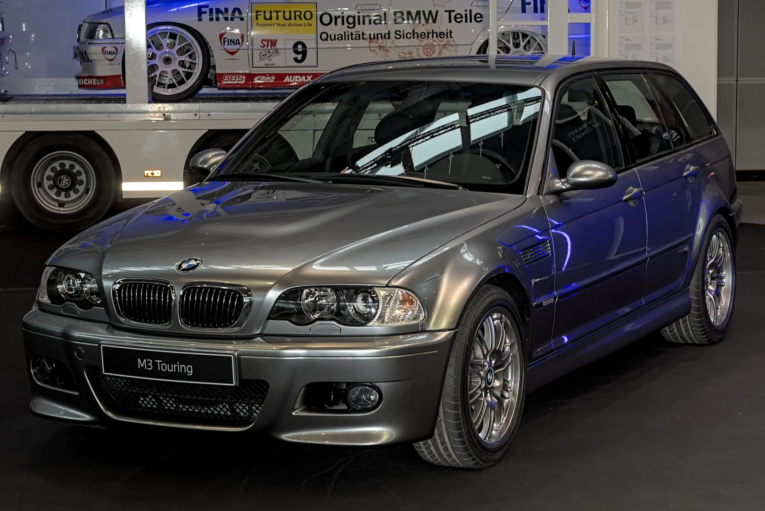 Silver BMW M3 E46, iconic sports car on winding road.