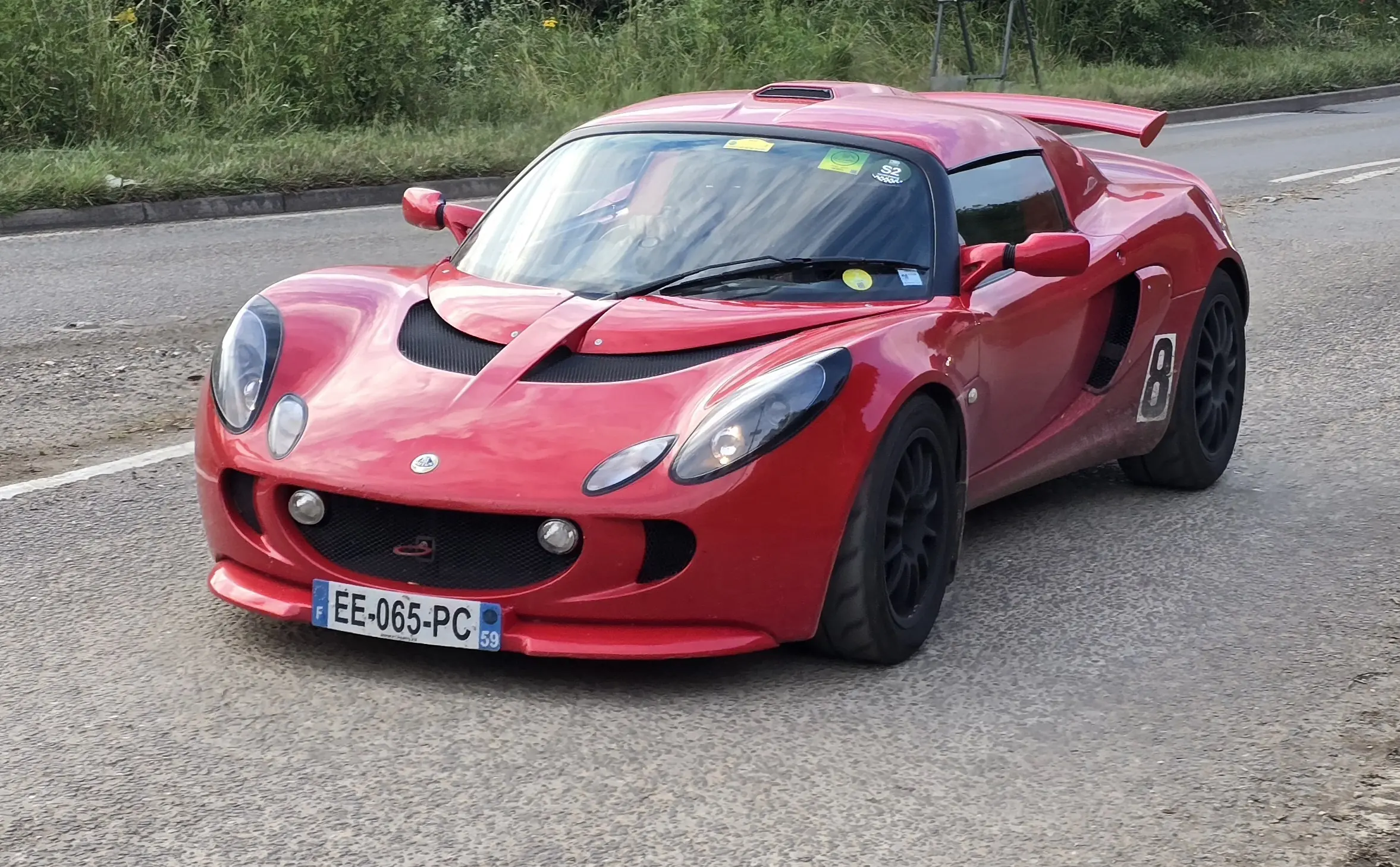 Sleek Lotus Exige sports car, vibrant color, dynamic motion blur.