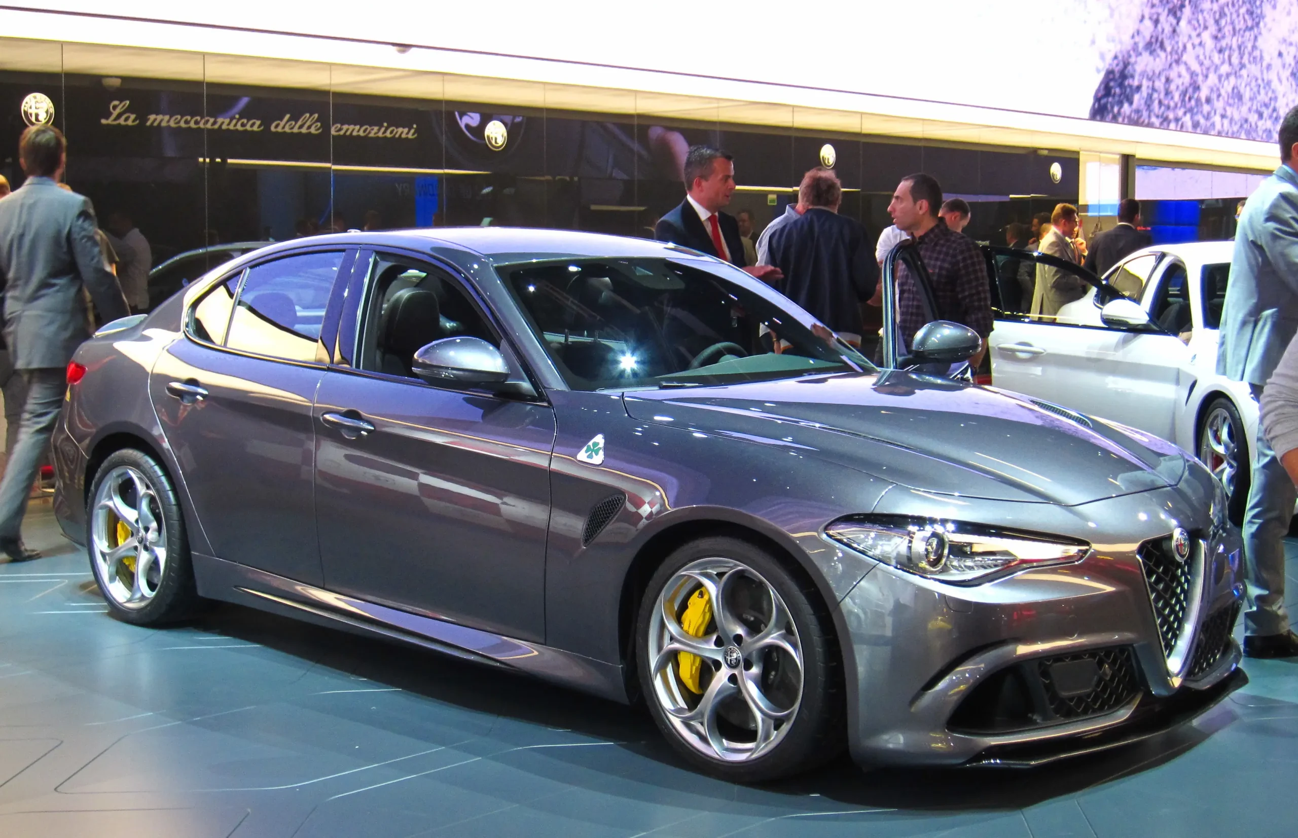 Red Alfa Romeo Giulia Quadrifoglio, sleek Italian sports sedan on road.