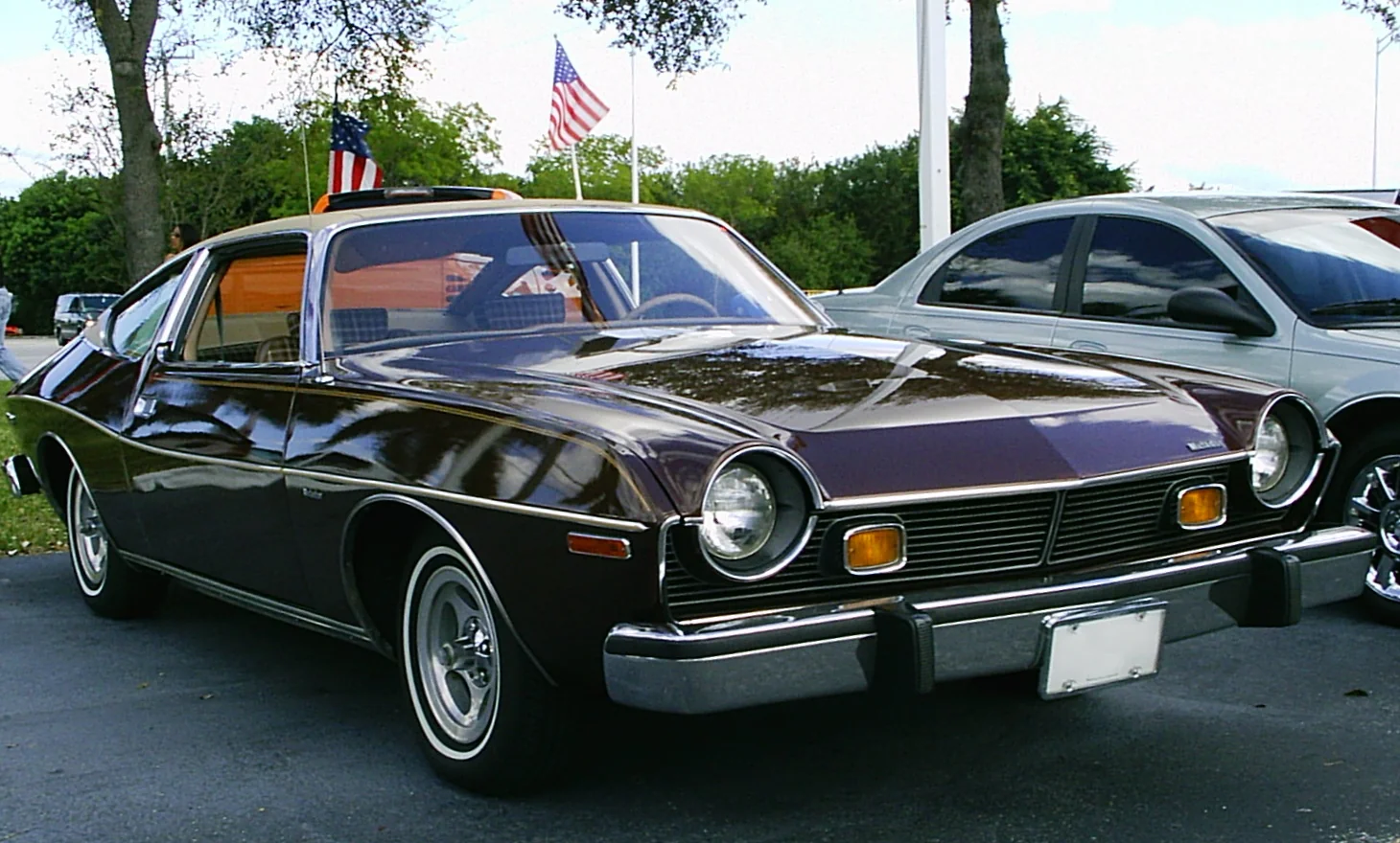 Classic 1970s AMC Matador car, metallic brown, parked on asphalt.