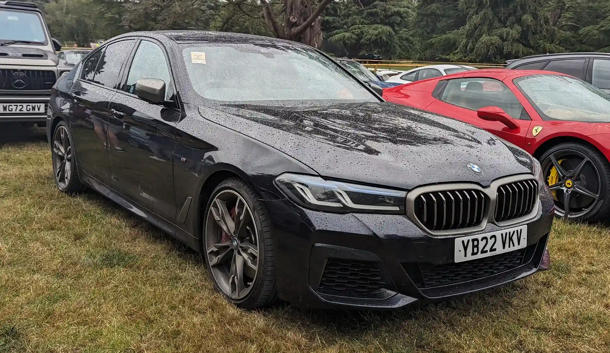 Sleek BMW M550i, dark blue, parked on an urban street