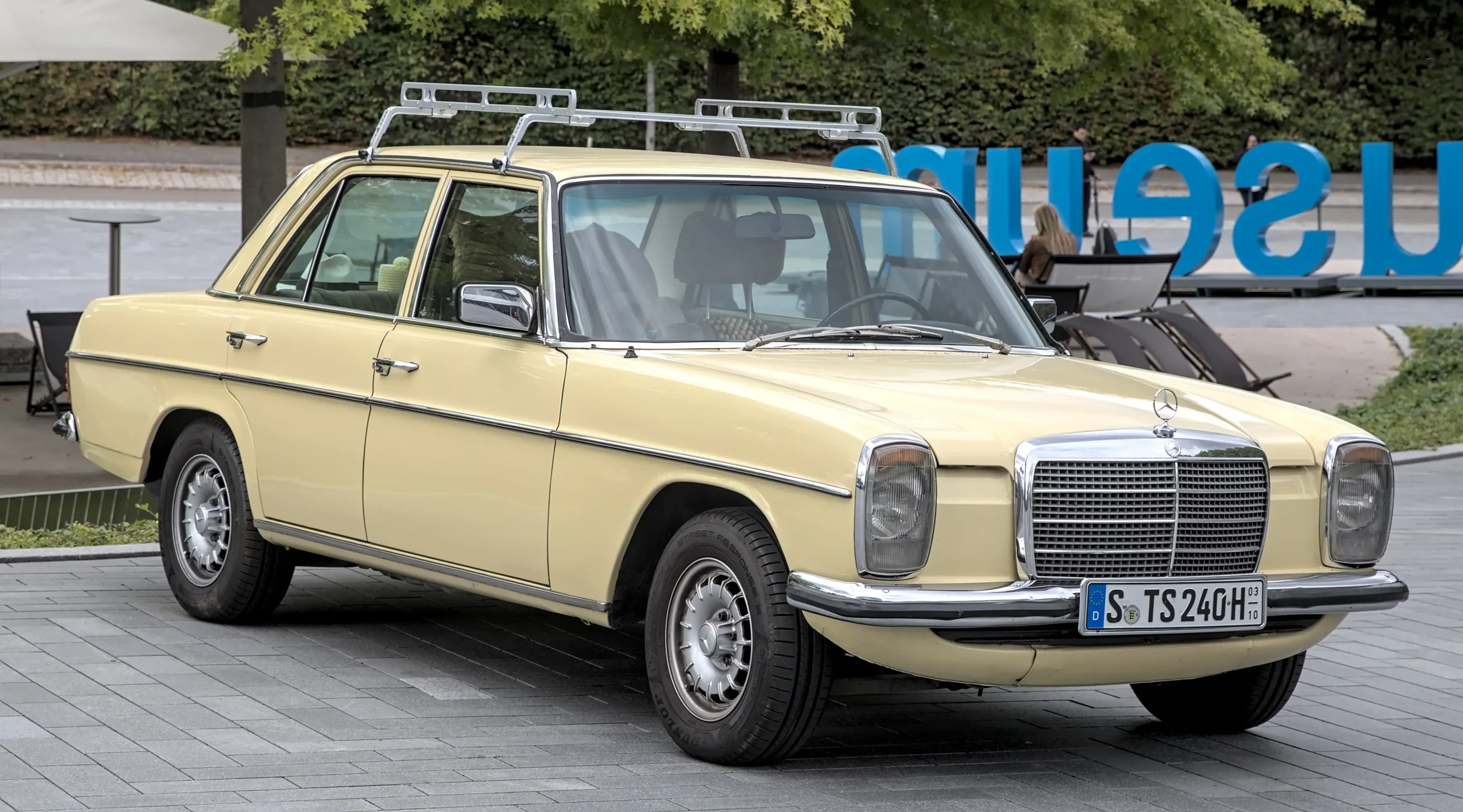 Silver Mercedes-Benz E-Class sedan parked on a sunny street.