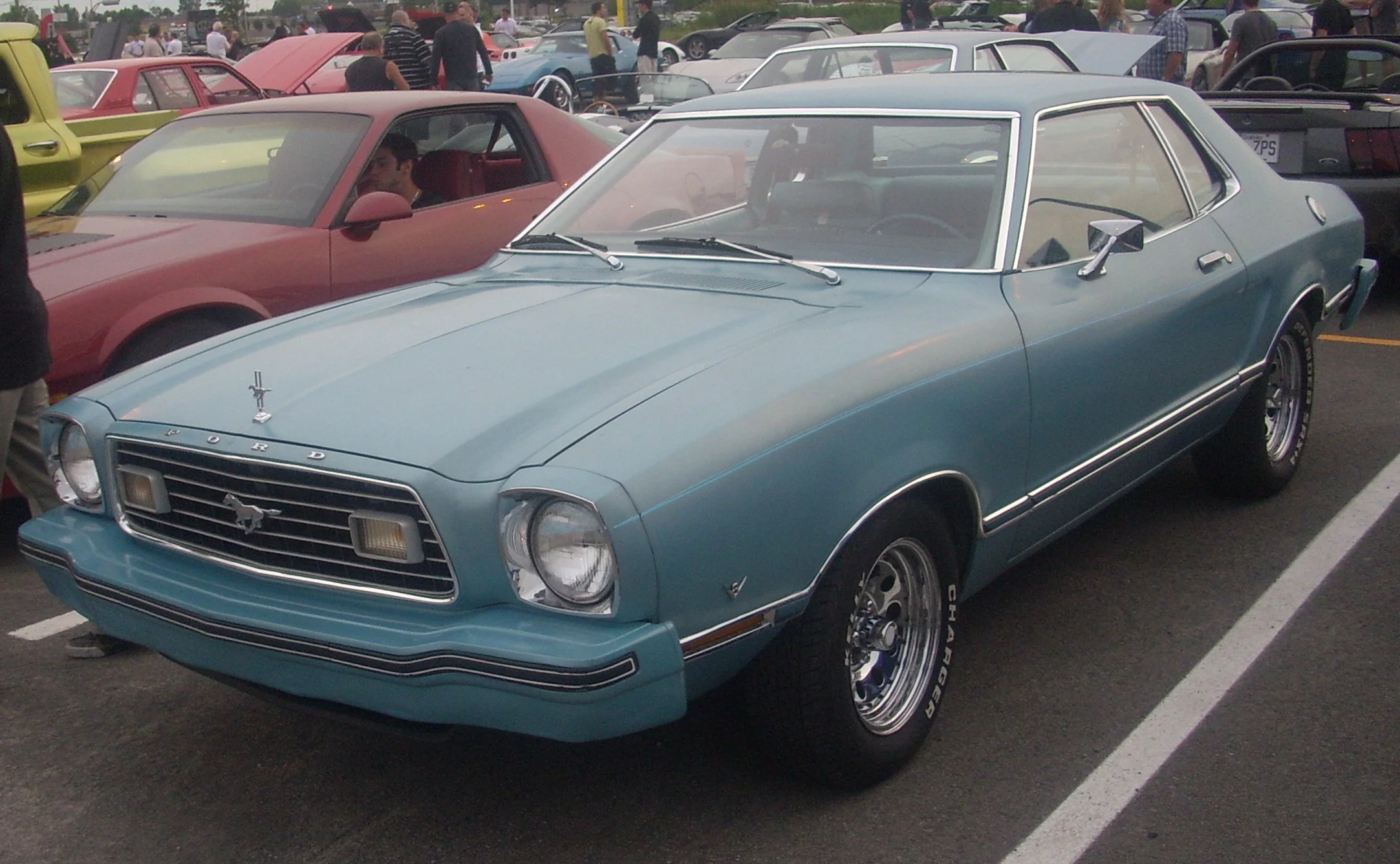 Red Ford Mustang II parked at a car show, seen from a low angle.