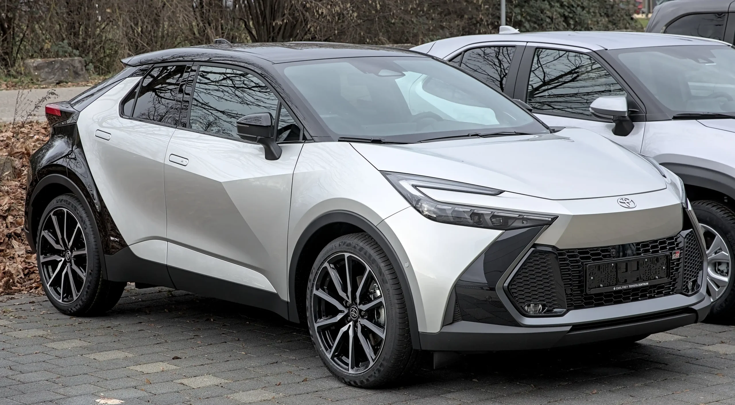 Sleek silver Toyota C-HR parked, showcasing its distinctive coupe-like design.