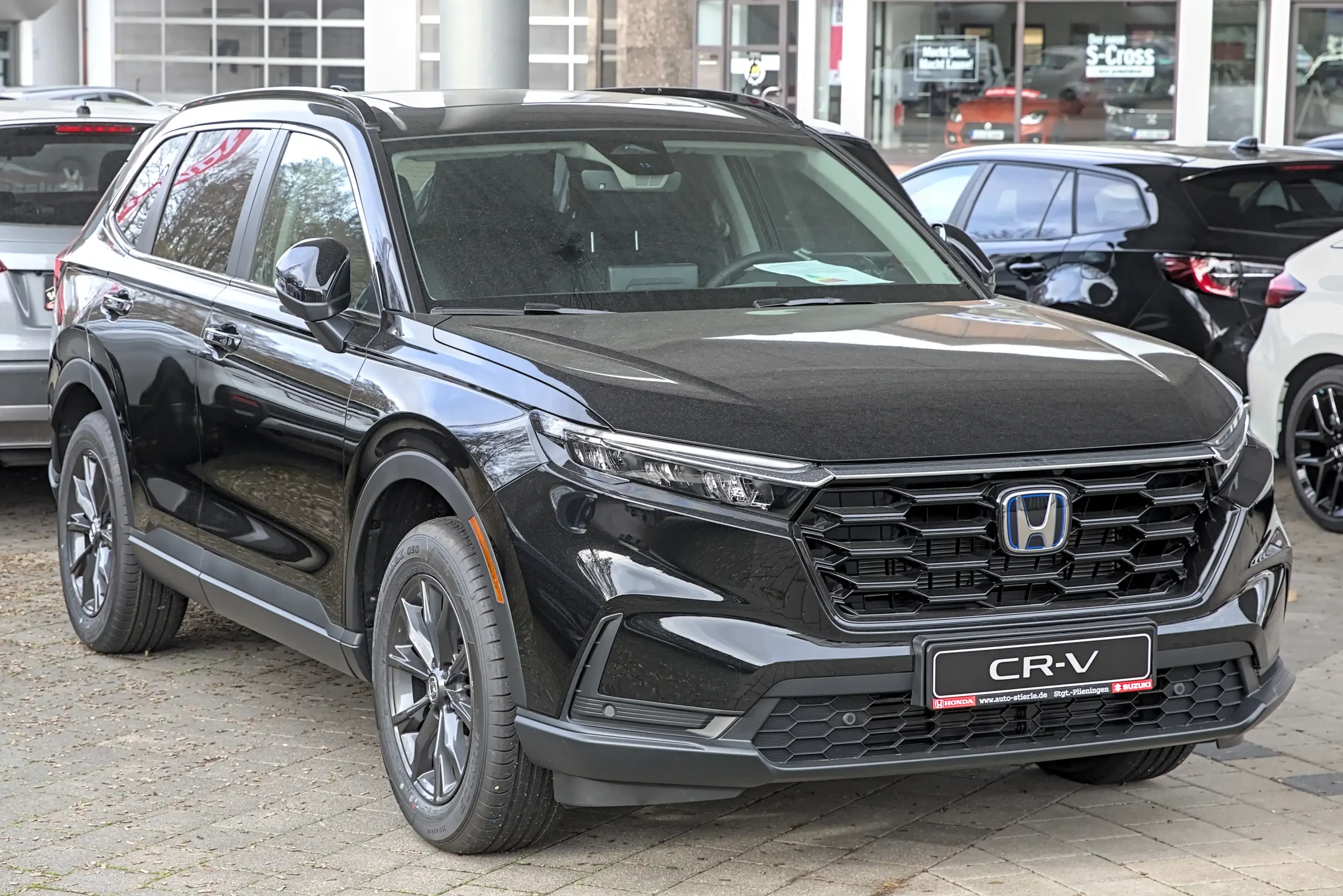 Silver Honda CR-V parked on a sunny suburban street.