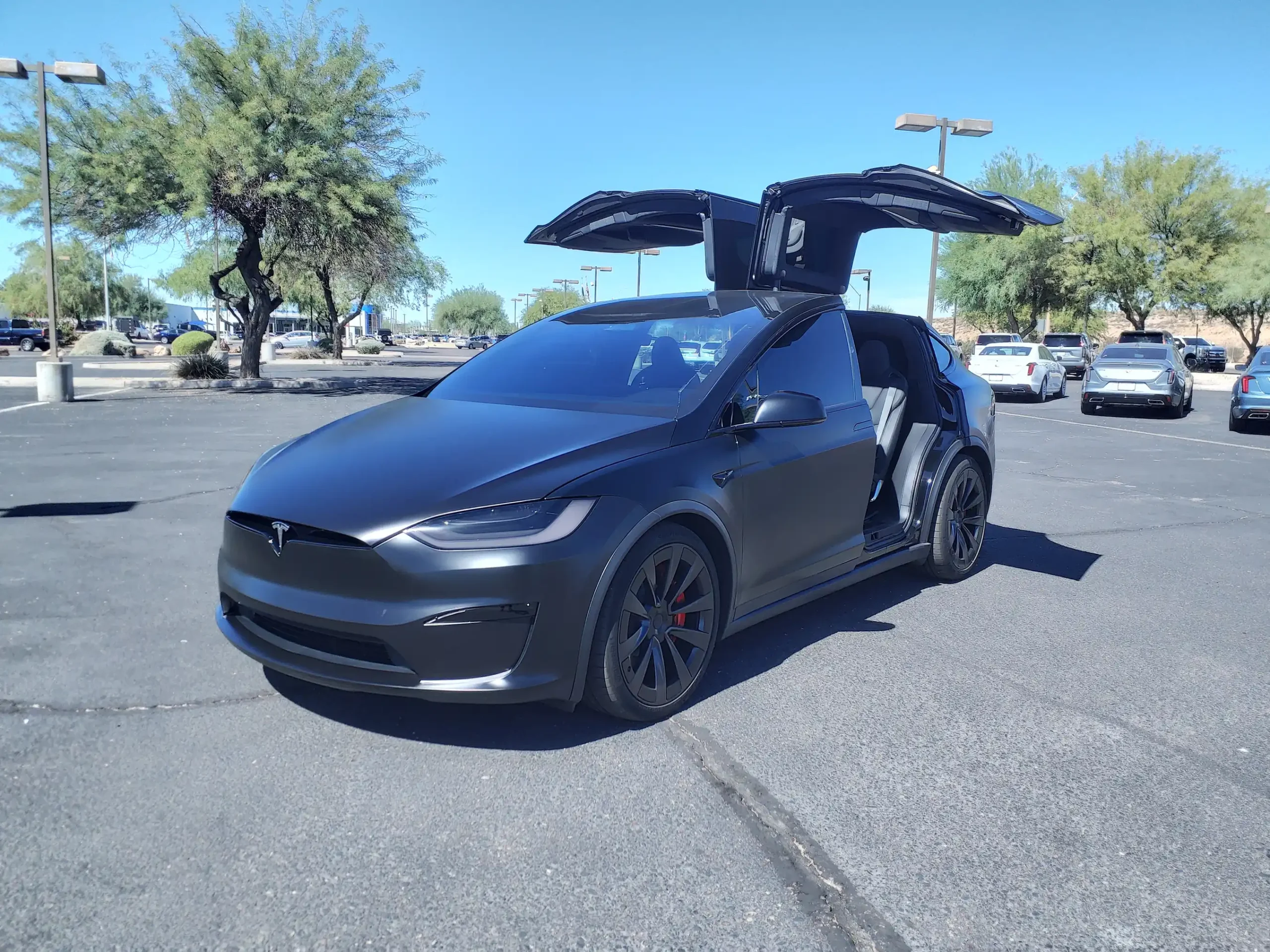 Red Tesla Model X Plaid parked; sleek, powerful electric SUV.
