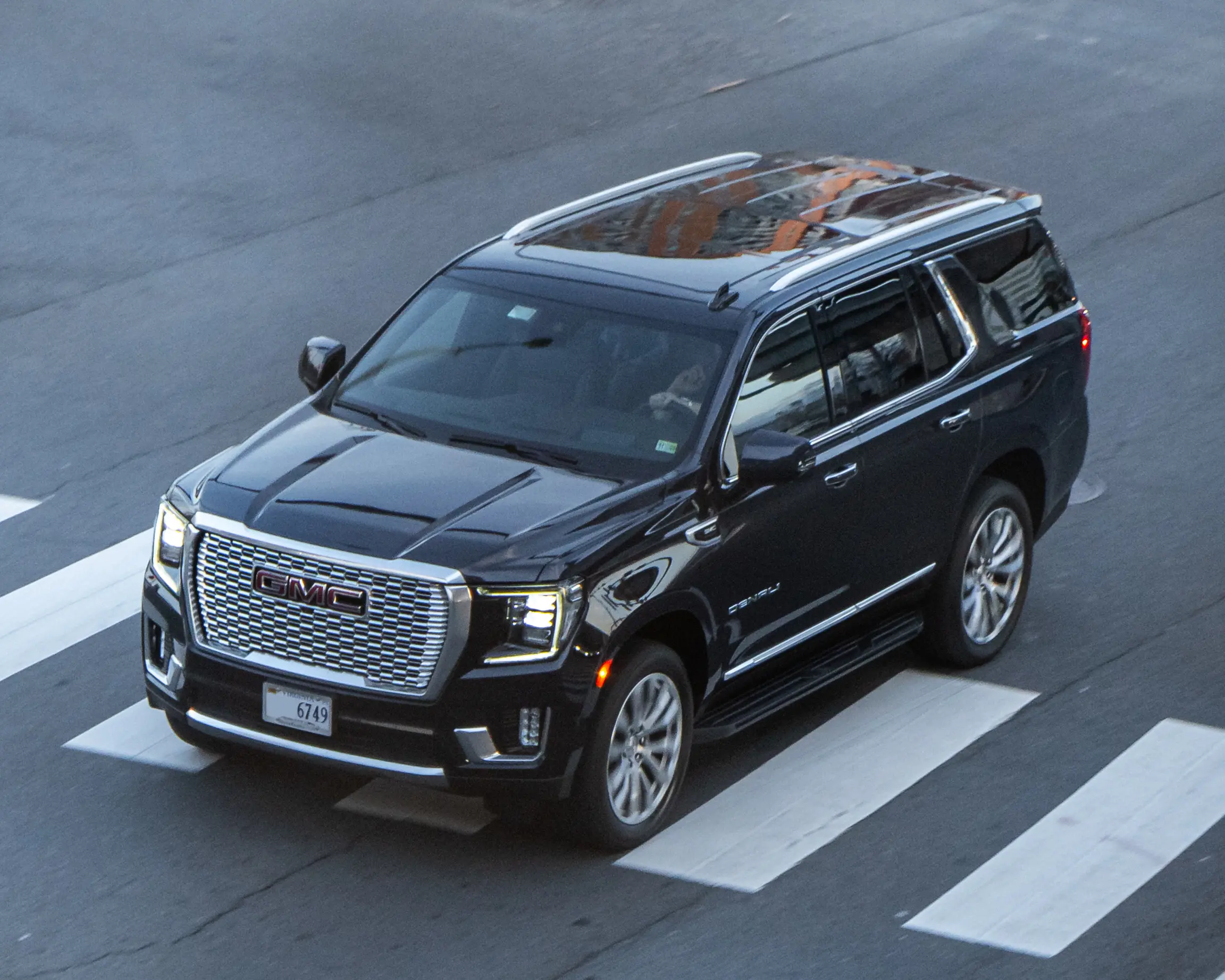 Silver GMC Yukon parked on a sunny suburban street.