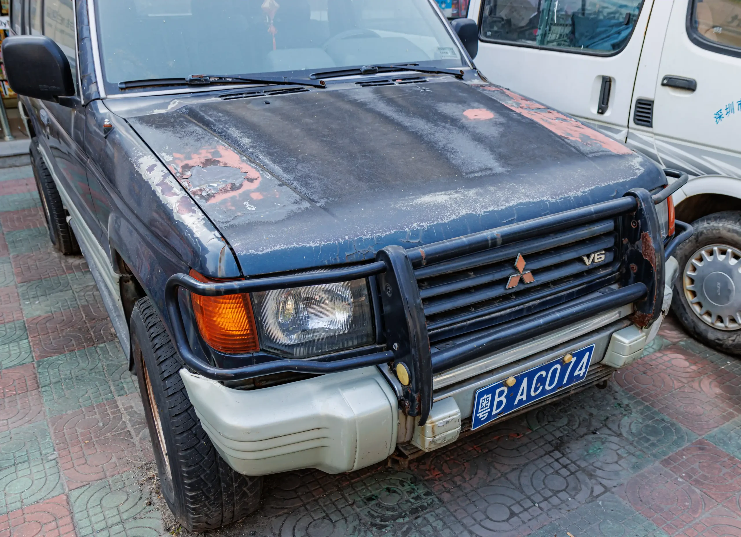 Mitsubishi Pajero/Montero SUV driving off-road on a rocky terrain. Dusty and powerful.