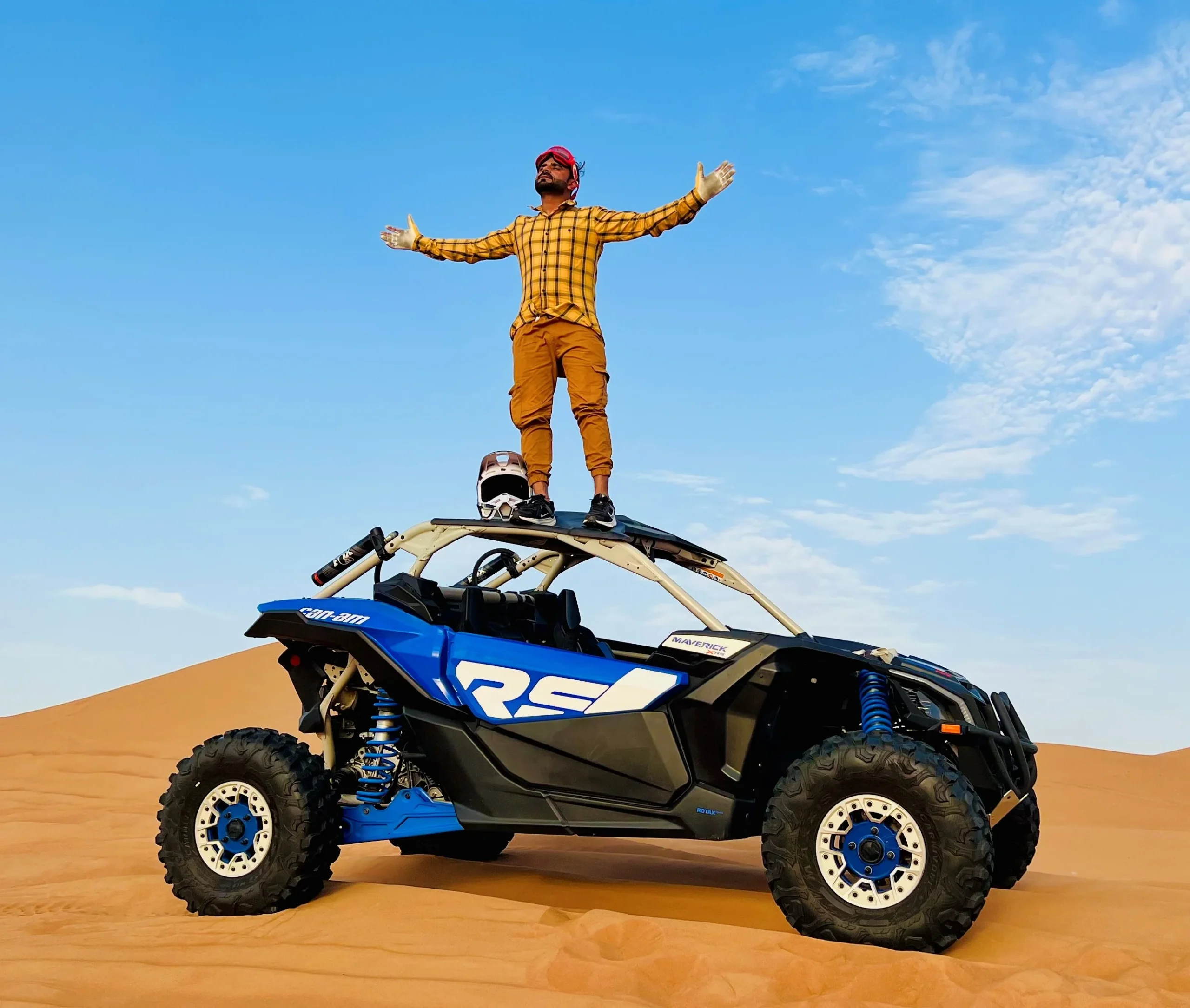 Red Can-Am Maverick X3 powers through a sandy desert landscape.