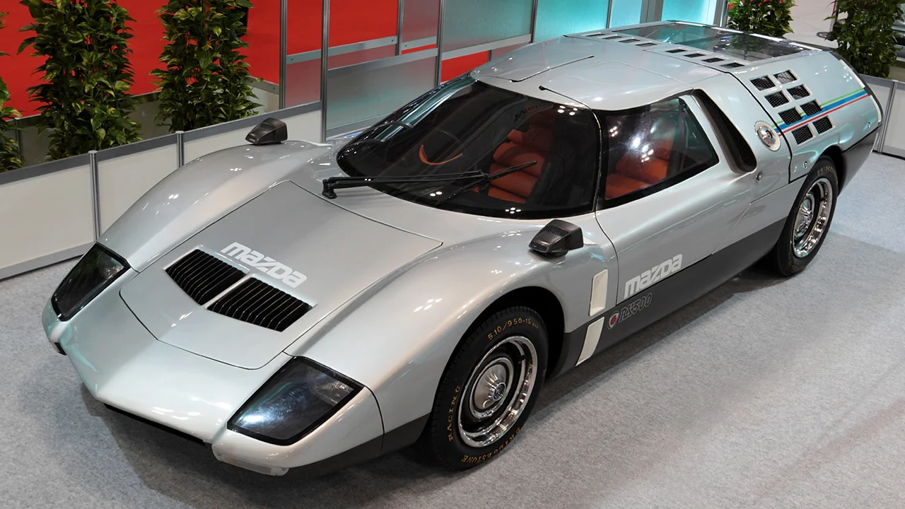 Retro-futuristic Mazda RX-500 sports car, sleek silver body, experimental design.
