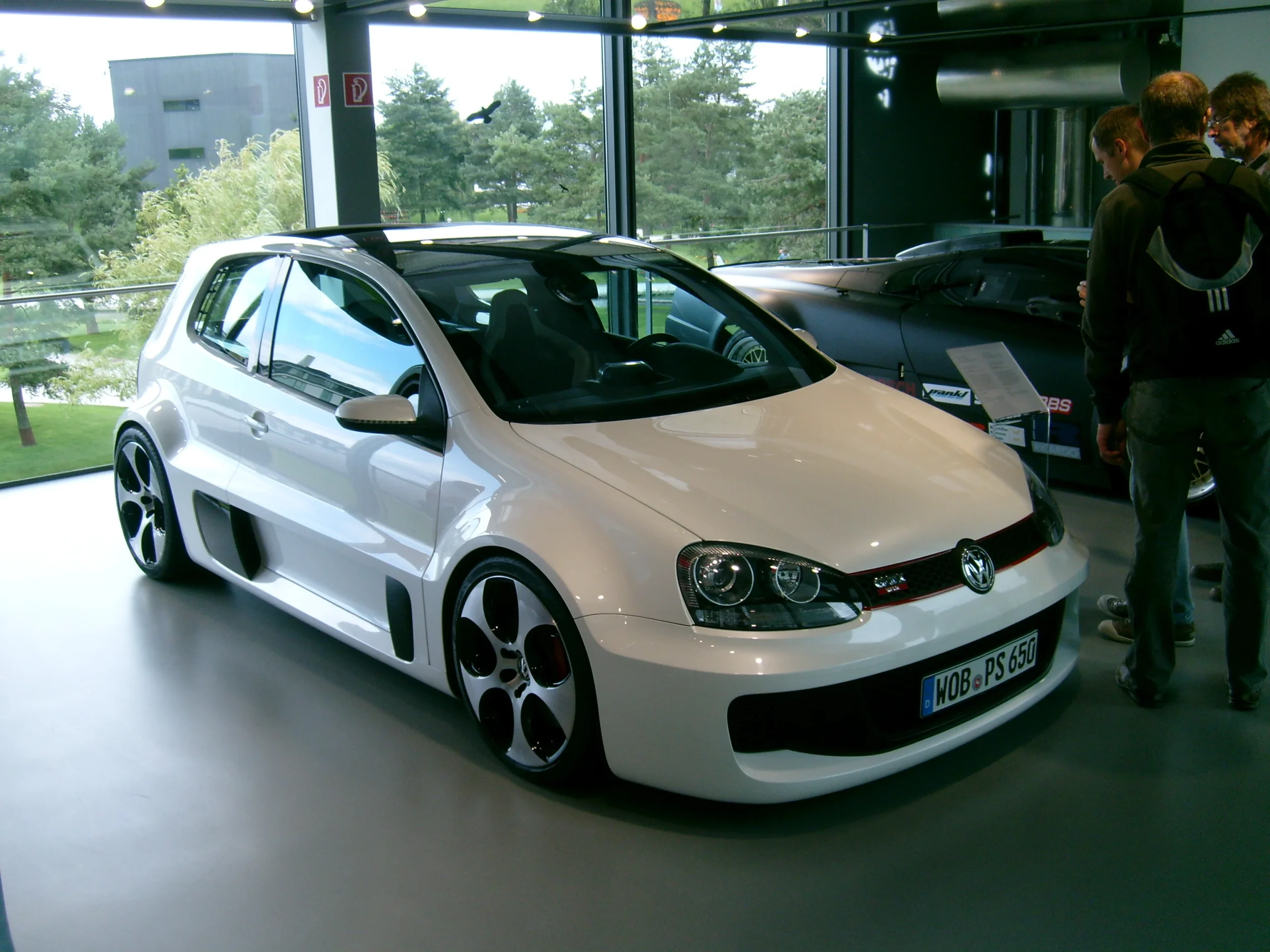 Modified VW Golf GTI W12-650, aggressive body kit, powerful engine showcased.