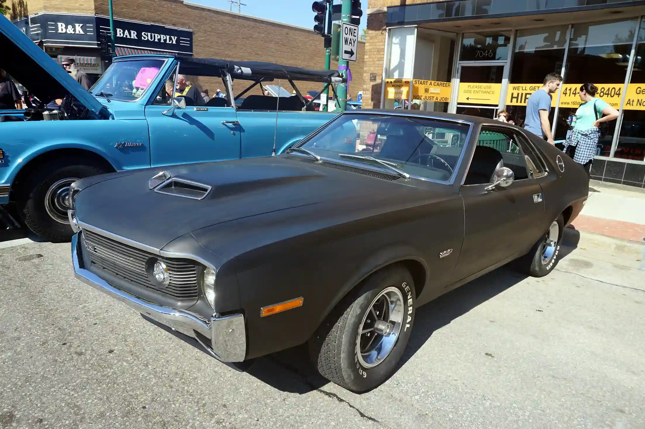 Sleek, orange AMC AMX parked on a sunny street, classic car