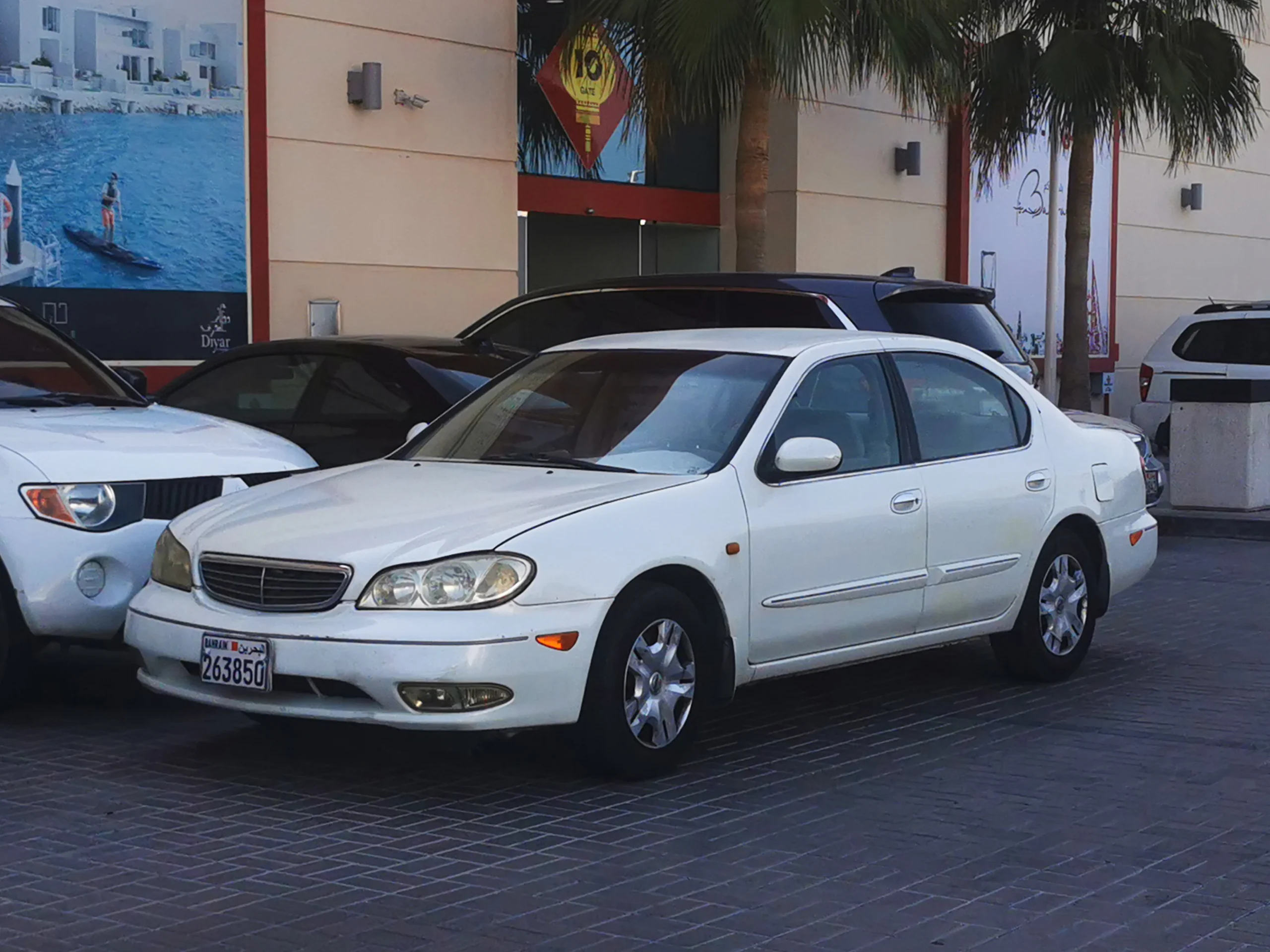 Sleek Nissan Maxima sedan, silver color, parked on city street.