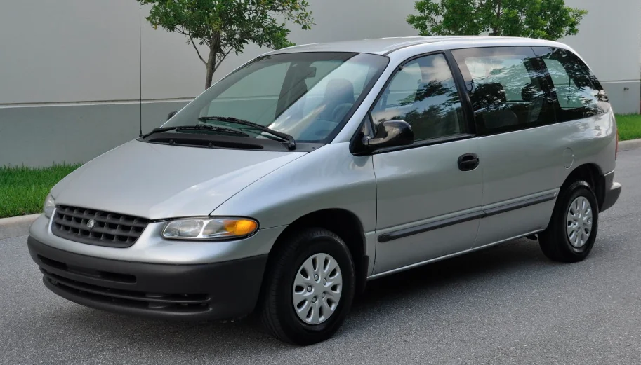 Maroon Plymouth Voyager minivan parked on a suburban street, daytime.