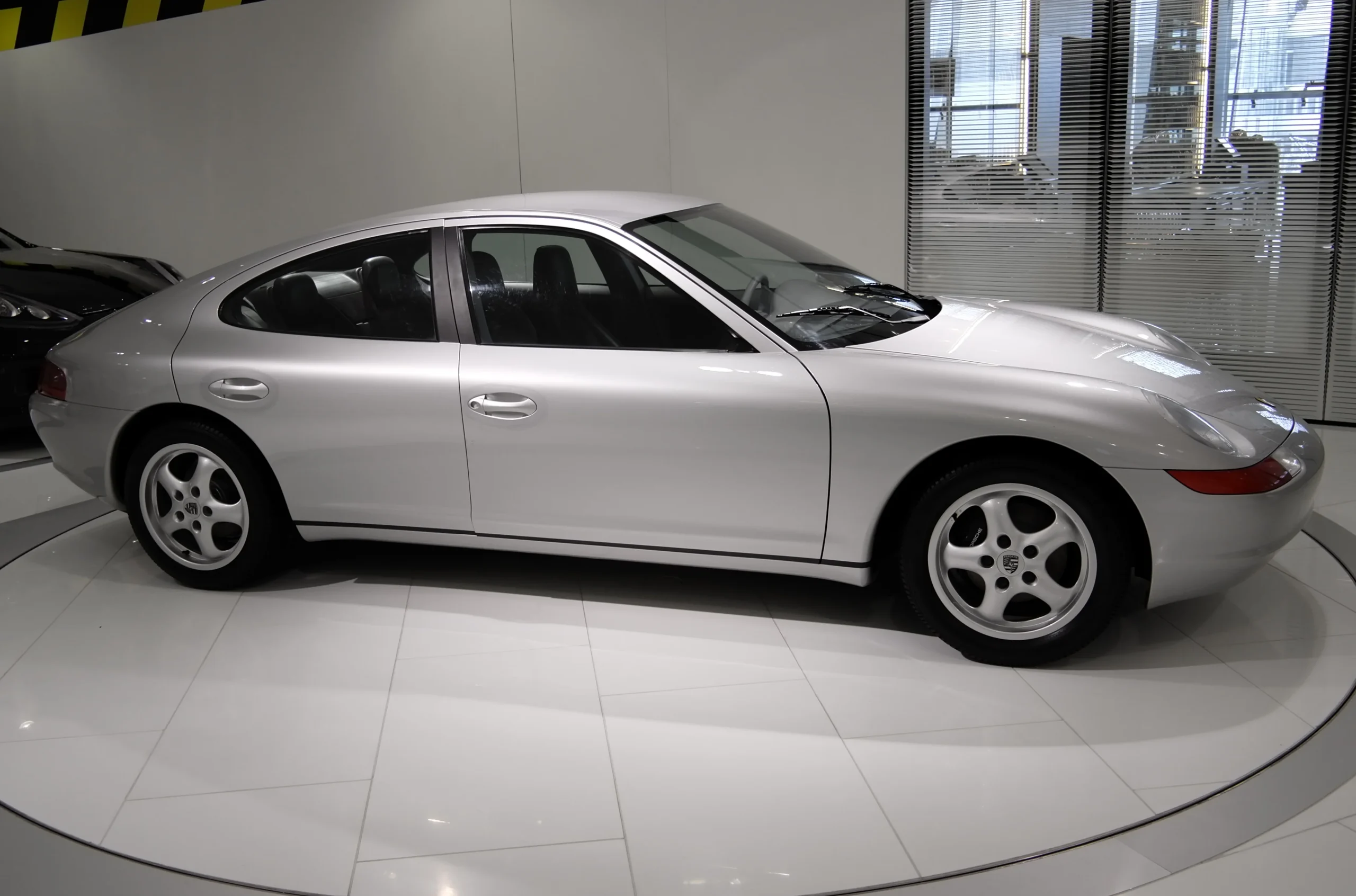 Sleek Porsche 989 prototype car in silver, showcasing its distinct design.