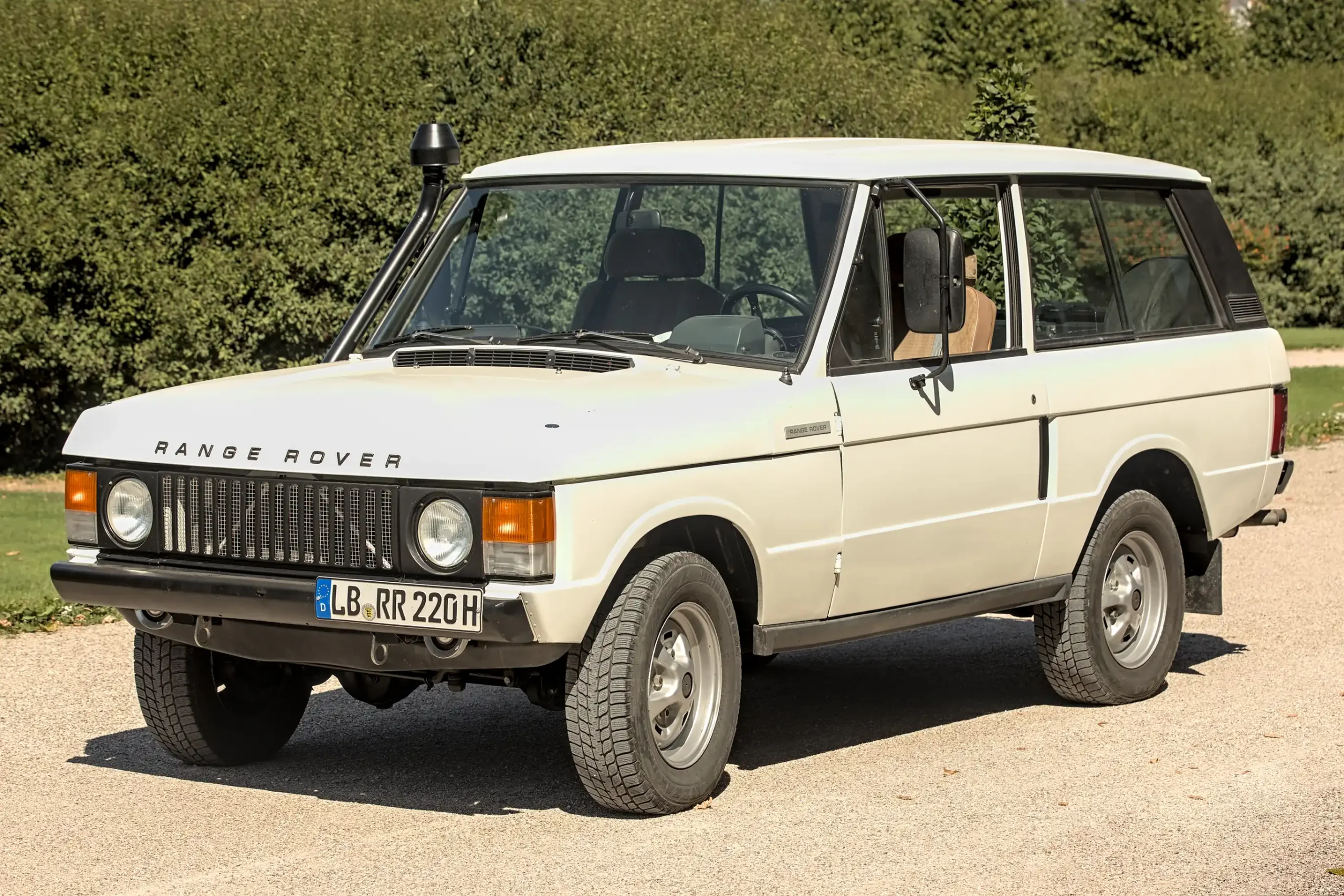 Vintage Range Rover Classic, a boxy, iconic off-road vehicle.