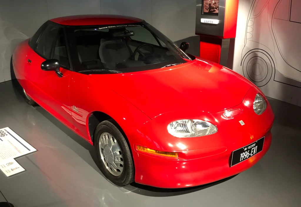 Sleek, silver GM EV1 electric car parked, highlighting its futuristic