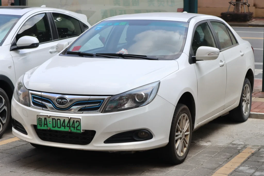 Silver BYD E5 electric sedan parked on a city street.