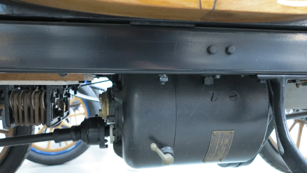 Vintage Baker Electric Car, shiny black finish, parked on cobblestone street.