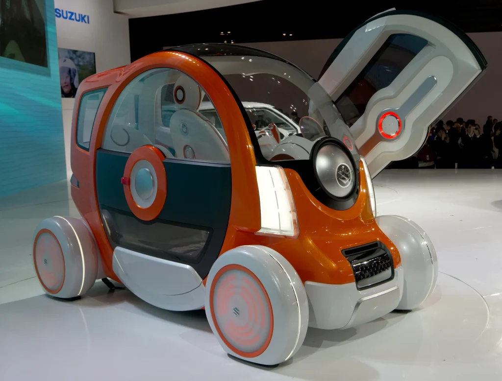 Small, futuristic Suzuki Q-Concept car, silver, minimalist design, urban mobility.