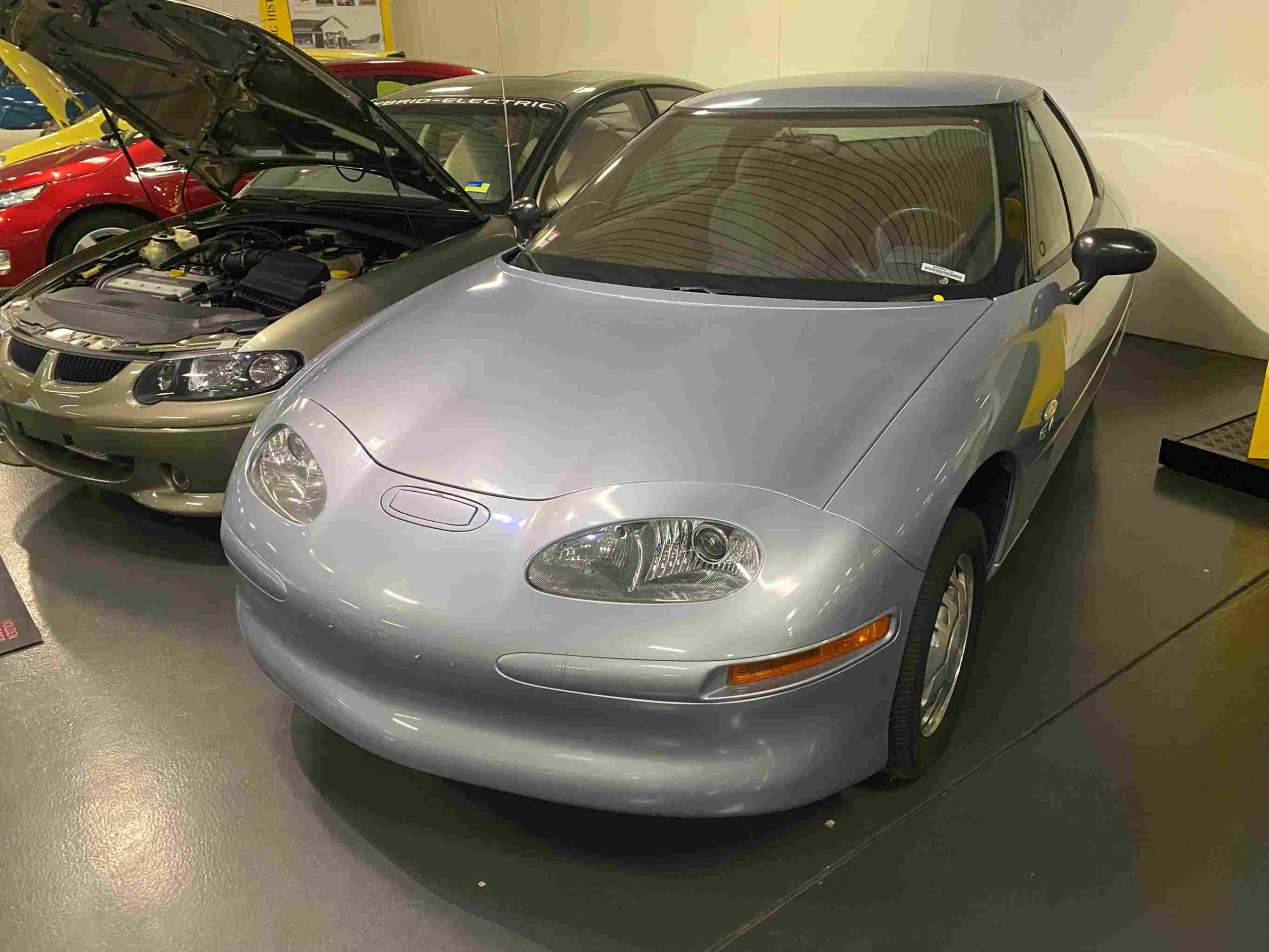 Sleek, silver GM EV1 electric car parked, futuristic and innovative