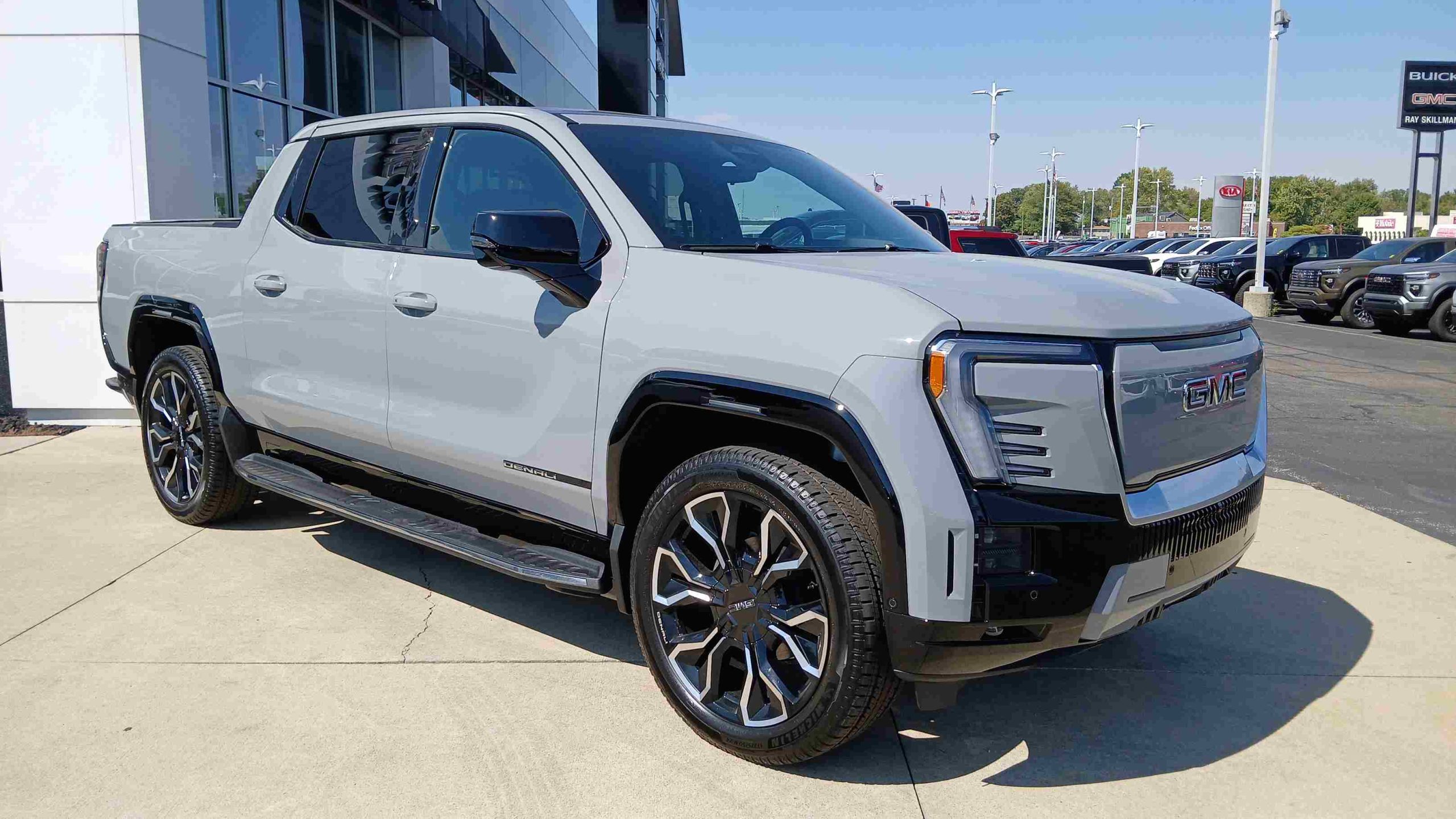 Sleek GMC Sierra EV pickup truck charging in a modern setting.