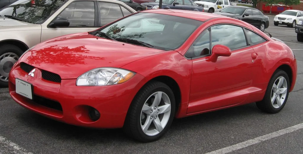 Red Mitsubishi Eclipse parked on a sunny street, sporty coupe.