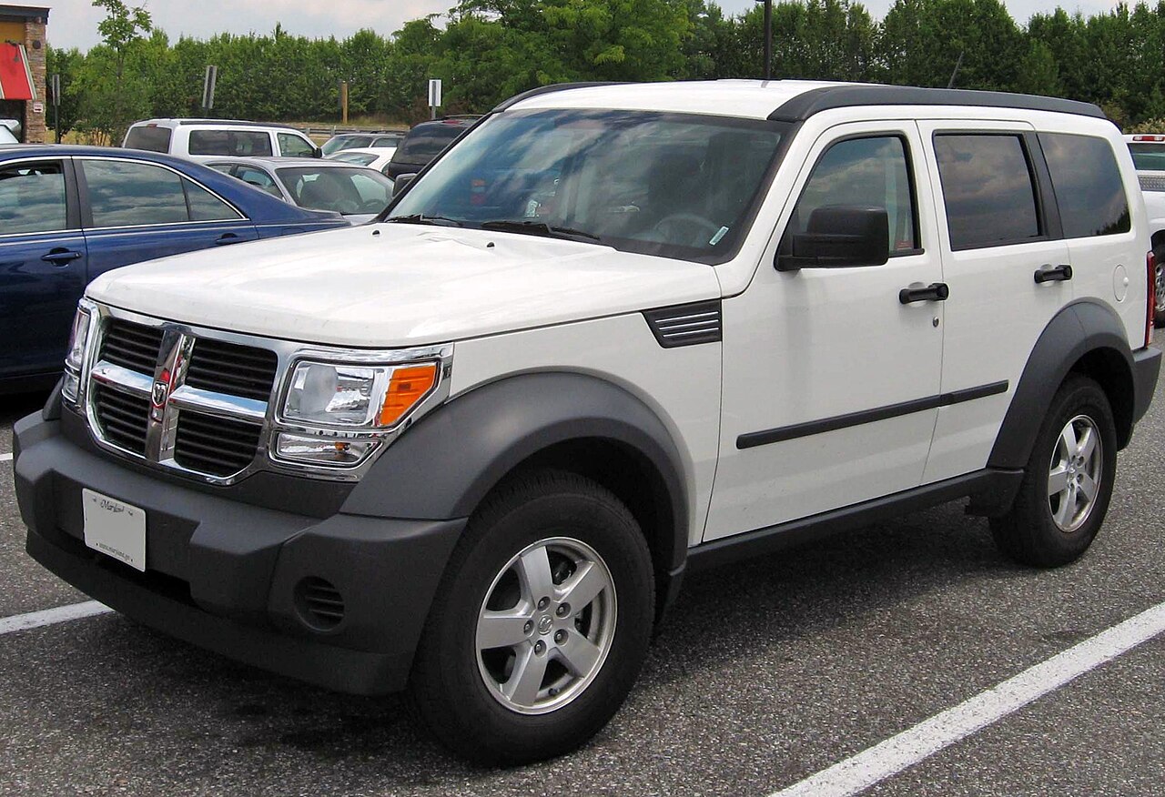 Dodge Nitro SUV with a bold, muscular design, parked on an open road, emphasizing its rugged and sporty appearance.