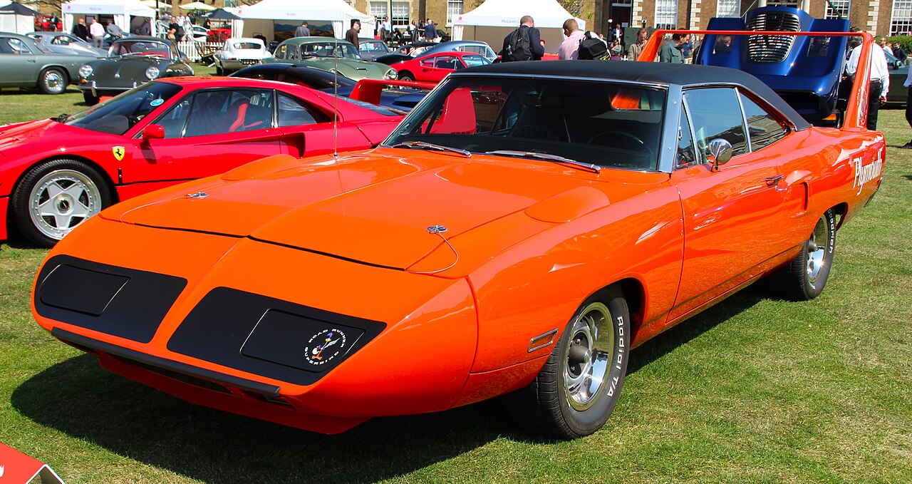 Bright orange 1970 Plymouth Superbird with distinctive rear wing and nose cone displayed at classic car show