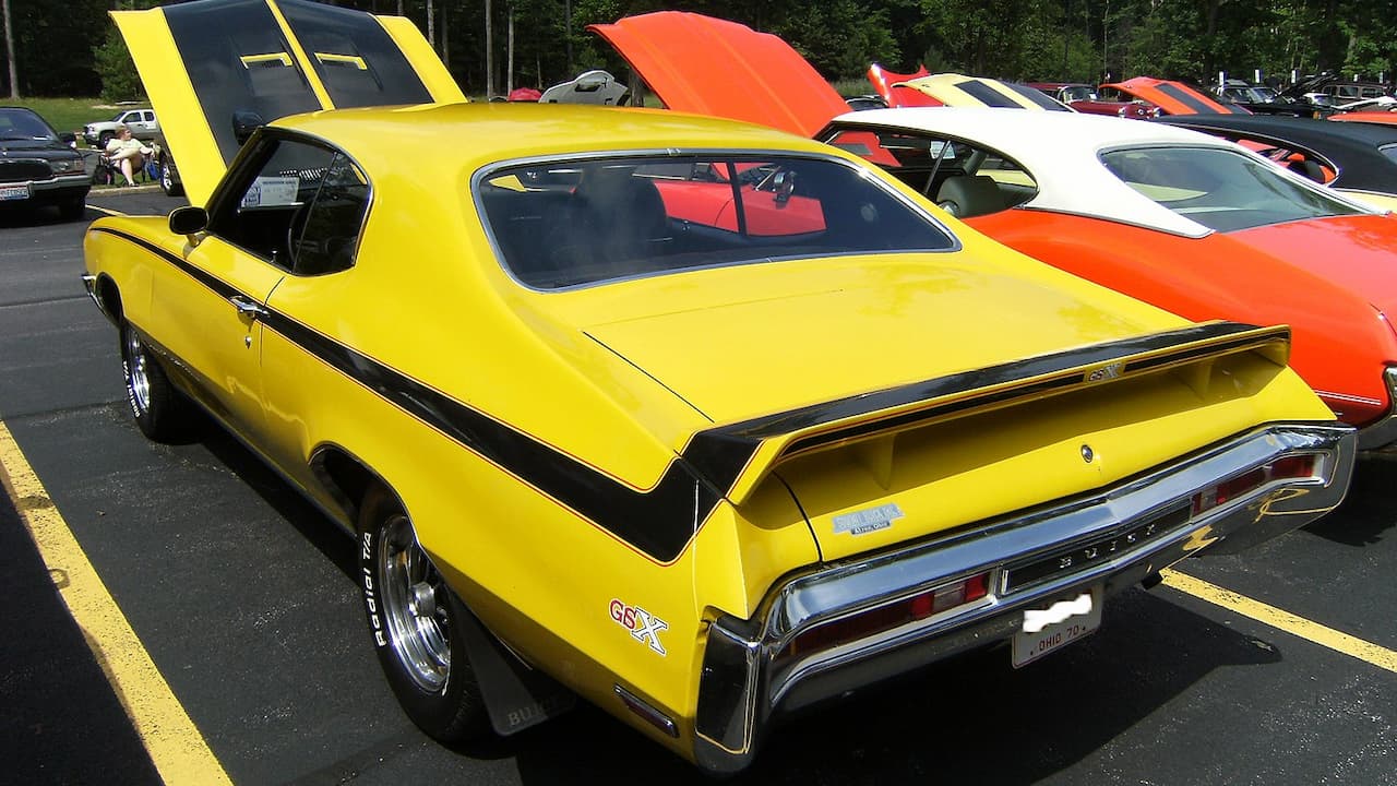 Bright yellow 1970 Buick GSX Stage 1 muscle car with black stripes at classic car show