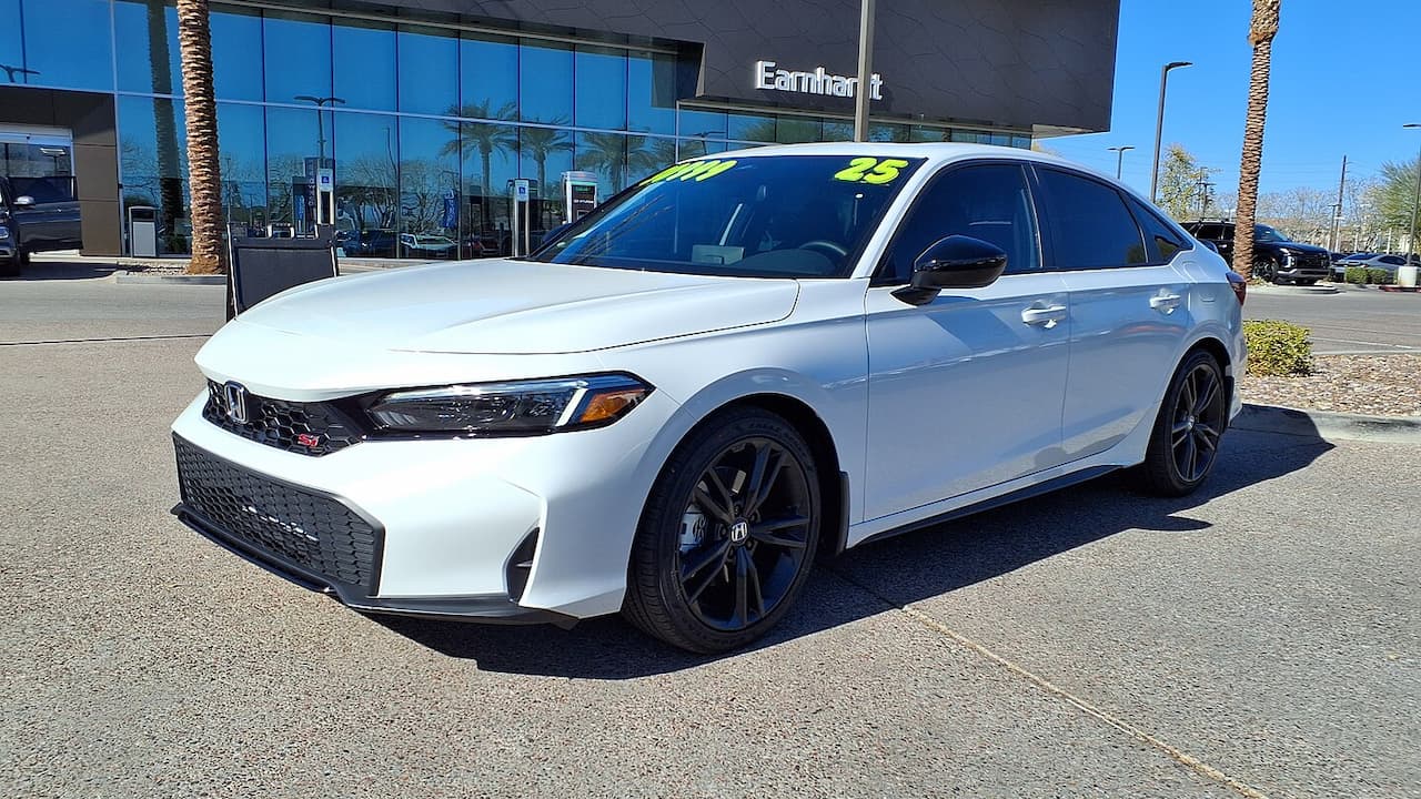 White 2025 Honda Civic Si with dark wheels and aggressive front styling parked at dealership with palm trees