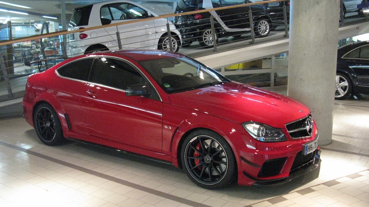 Red Mercedes C63 AMG Black Series with black wheels parked in modern multi-level parking garage