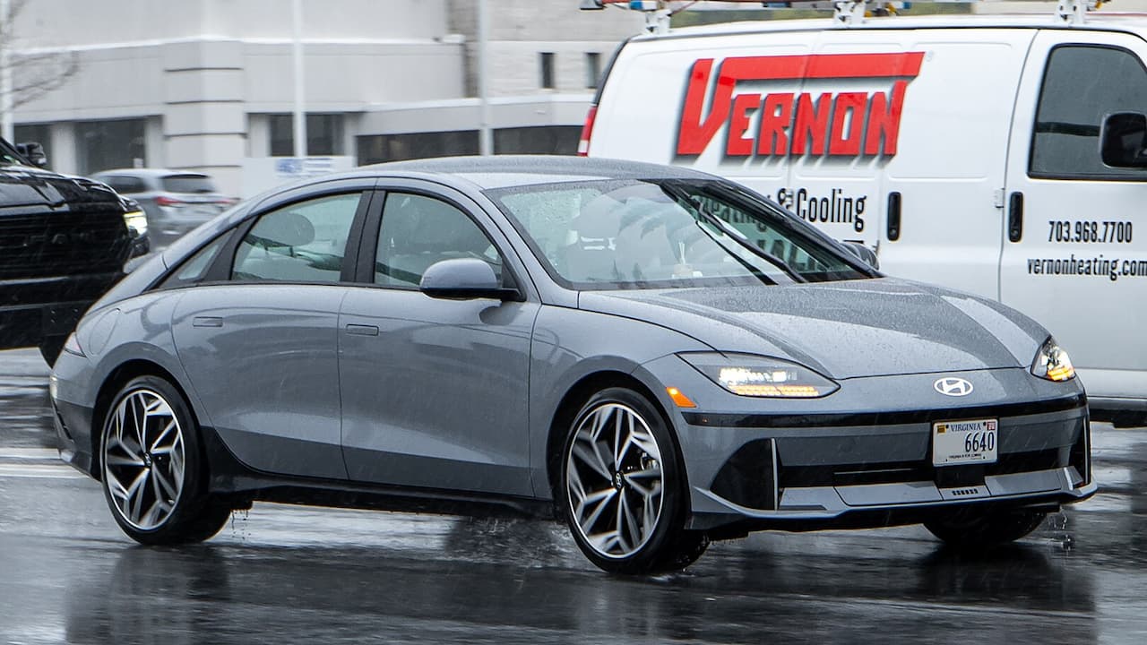 Gray 2025 Hyundai Ioniq 6 electric vehicle with streamlined design and distinctive wheels on wet pavement with Virginia license plate