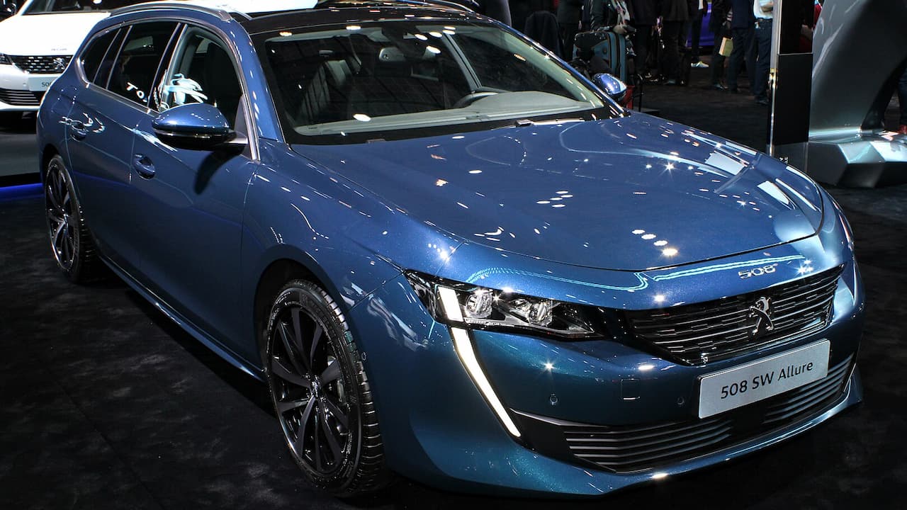 Blue Peugeot 508 SW displayed at motor show with distinctive LED headlights and black alloy wheels
