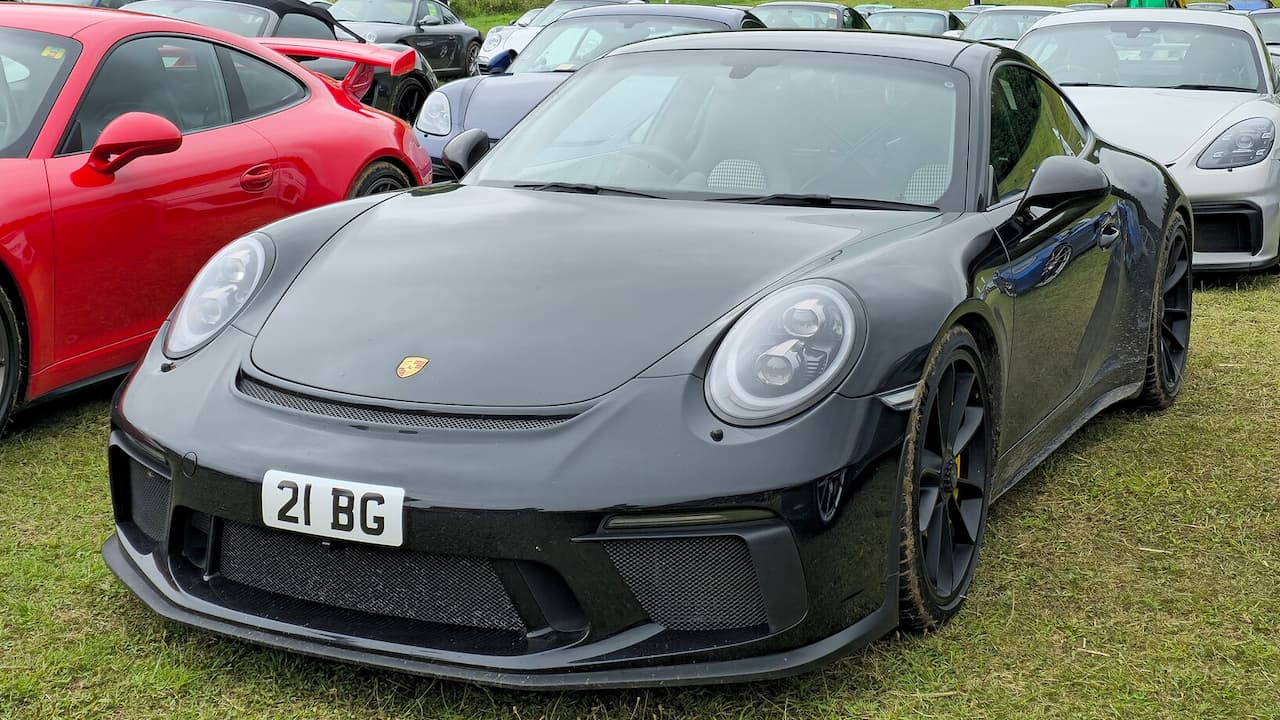 Gray Porsche 911 GT3 Touring (991.2) with carbon fiber details and license plate "21 BG" at car show