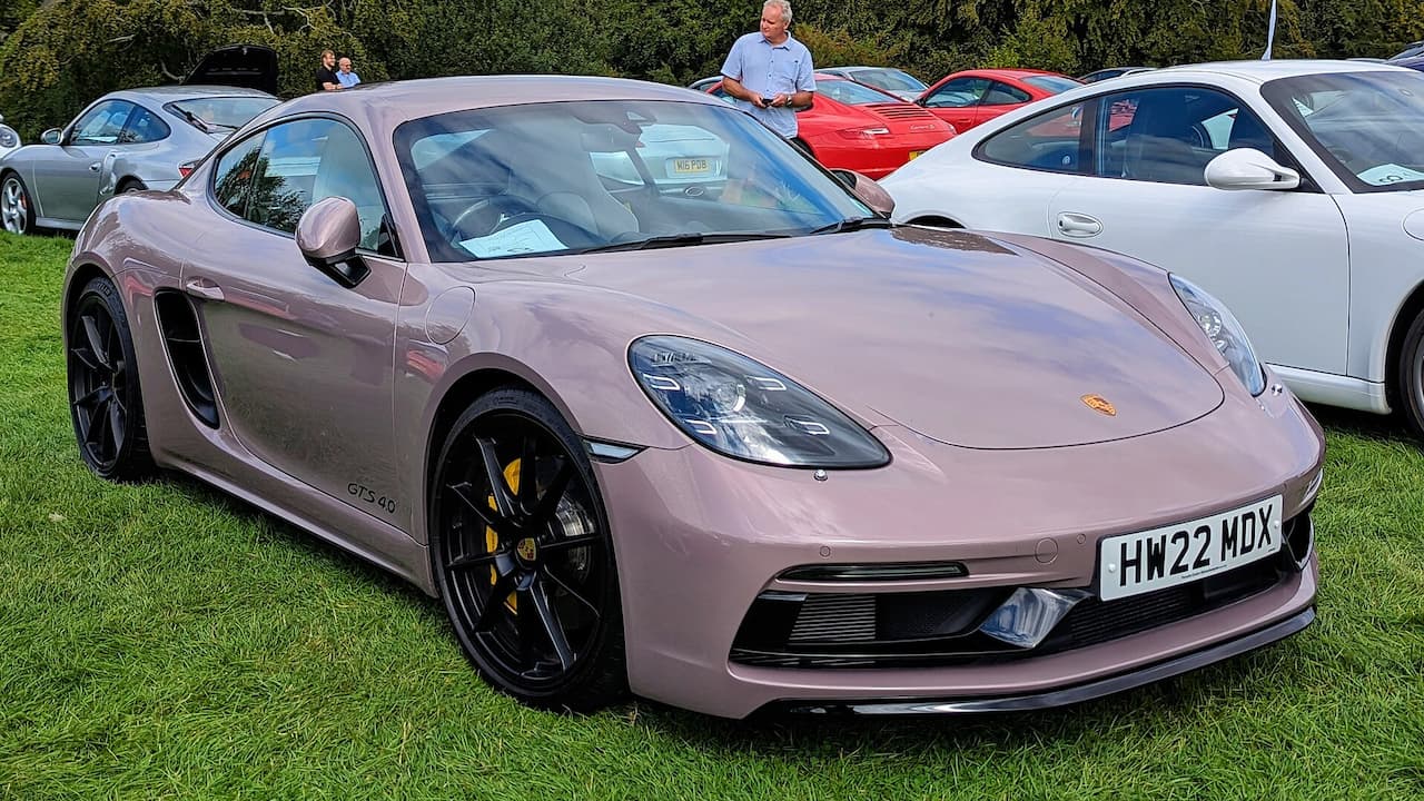 Porsche 718 Cayman GTS 4.0 with license plate HW22 HDX parked on grass at car show event