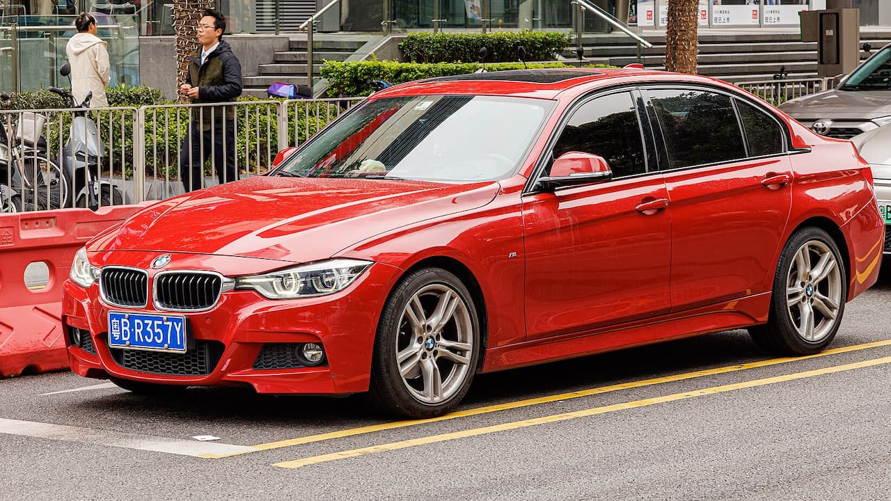 Red 2025 BMW 3-Series parked on street with distinctive kidney grille and Chinese license plate