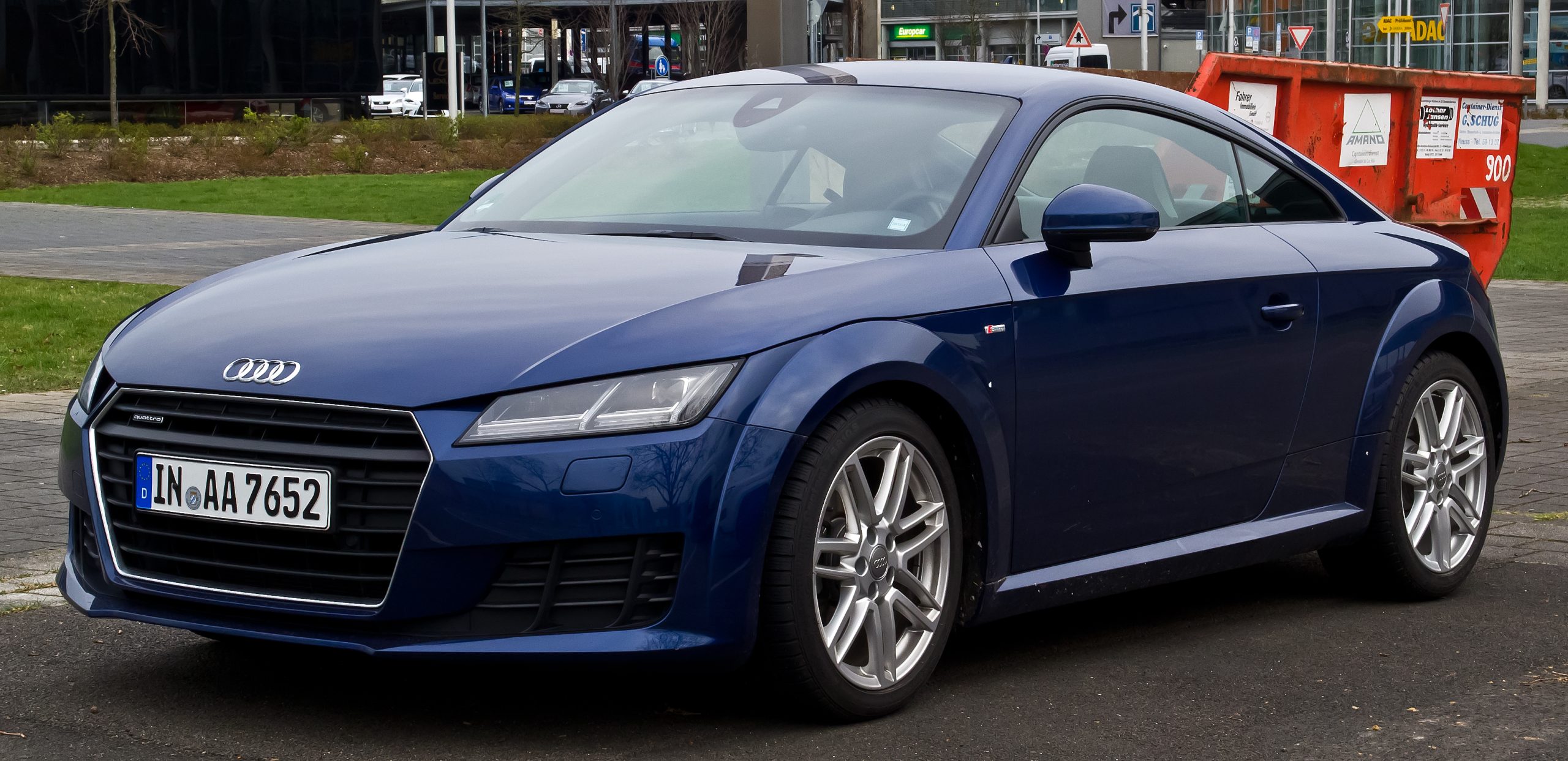 Dark blue 2015 Audi TT with German license plate and silver wheels parked on street near buildings