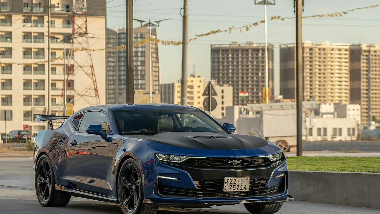 Chevrolet 'Exorcist' Camaro parked on urban street with modern high-rise buildings and construction cranes in background
