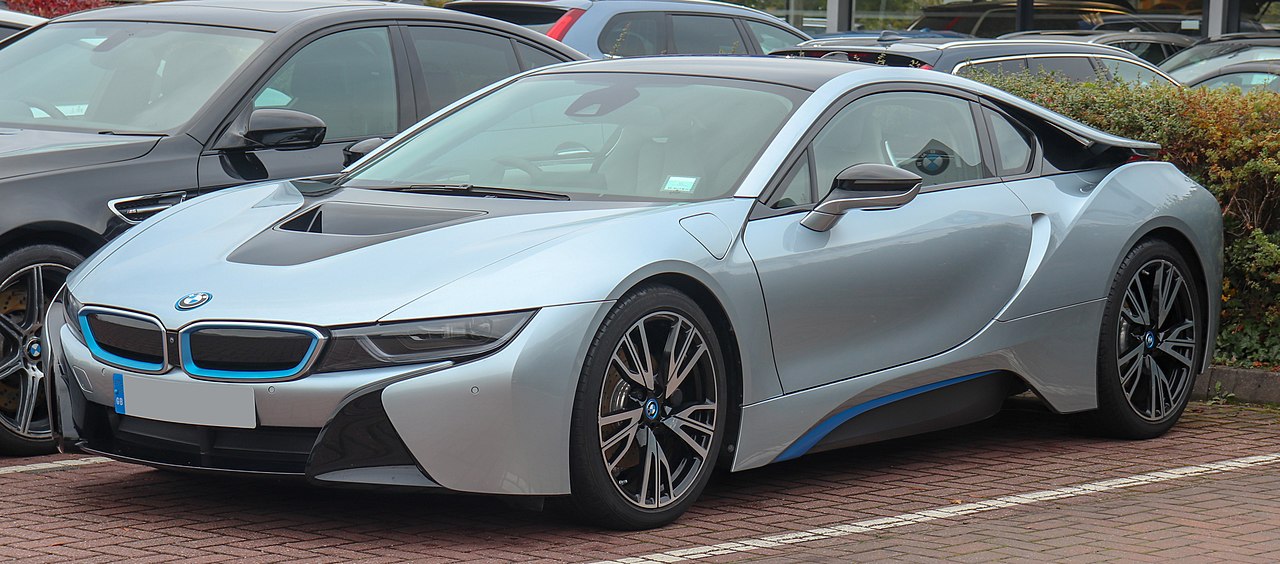 Silver BMW i8 with blue accents parked in lot with distinctive futuristic design and aerodynamic bodywork