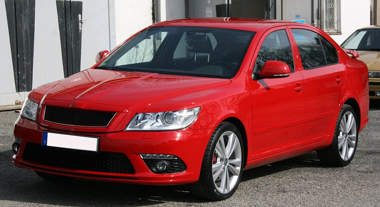 Red Skoda Octavia RS with black mesh grille and silver alloy wheels parked on concrete surface