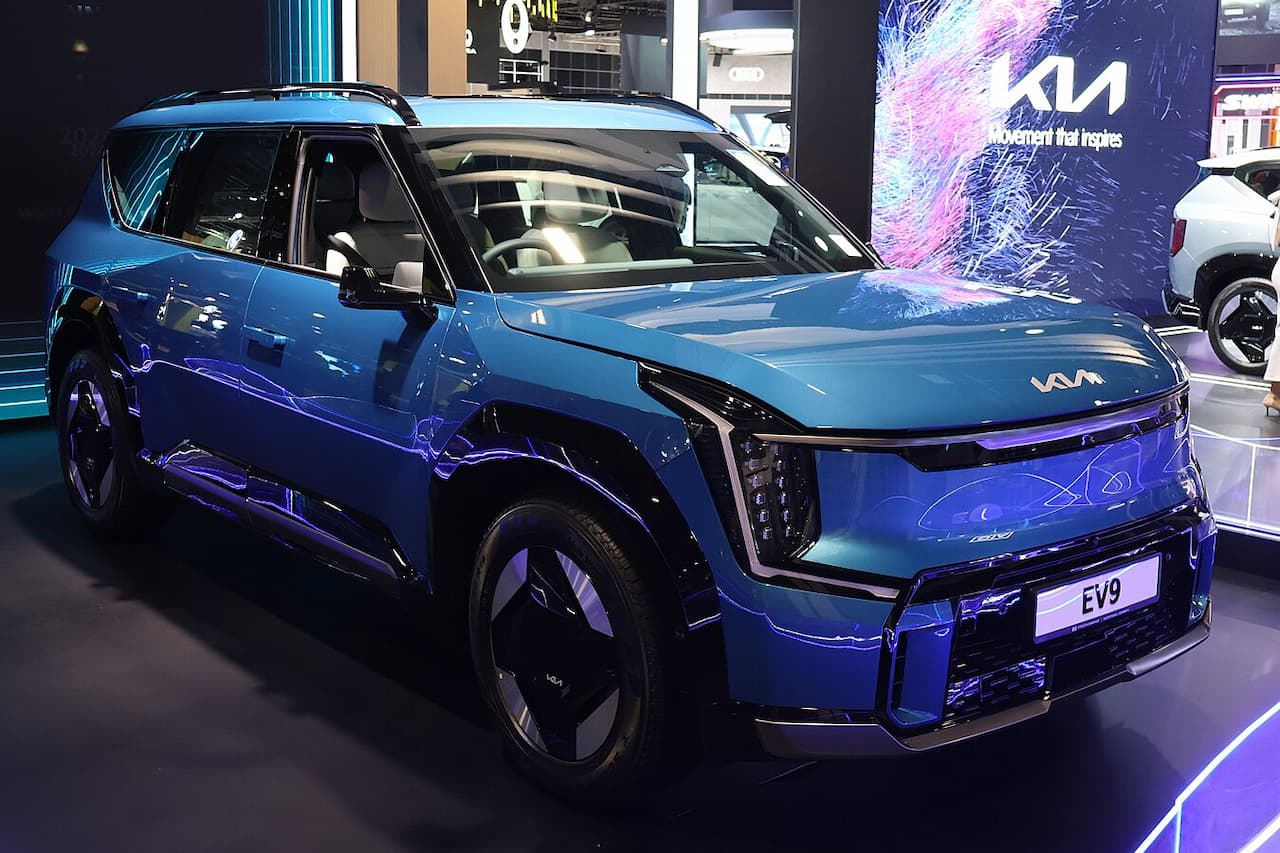Blue 2025 Kia EV9 electric SUV with futuristic design displayed at auto show with KIA branding and EV9 nameplate