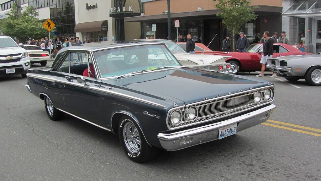 Black 1965 Dodge Coronet 426 Wedge classic muscle car displayed on street at outdoor car show event