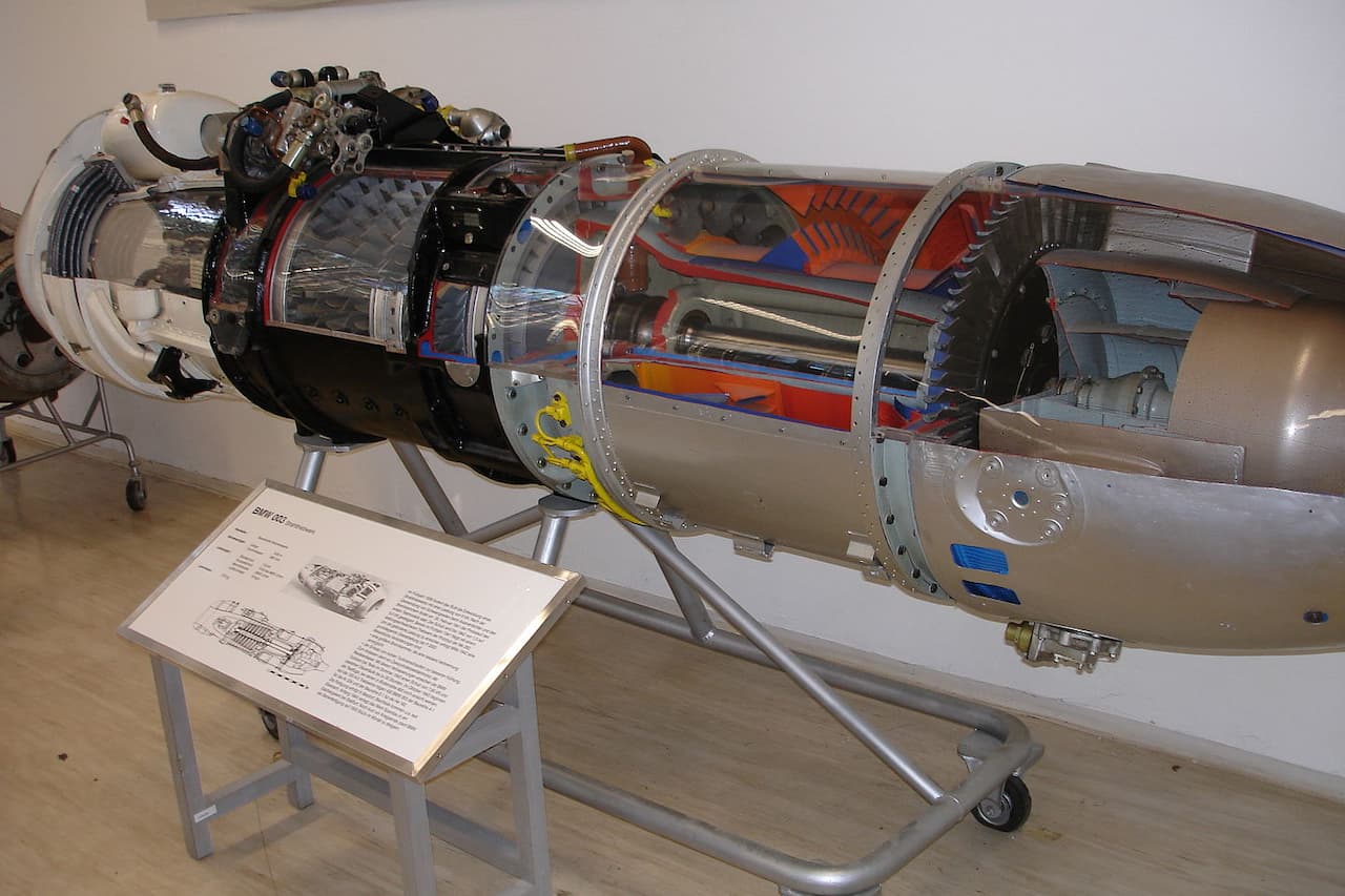 Cutaway display of BMW 003 axial-flow turbojet engine showing internal components, mounted on stand with informational placard