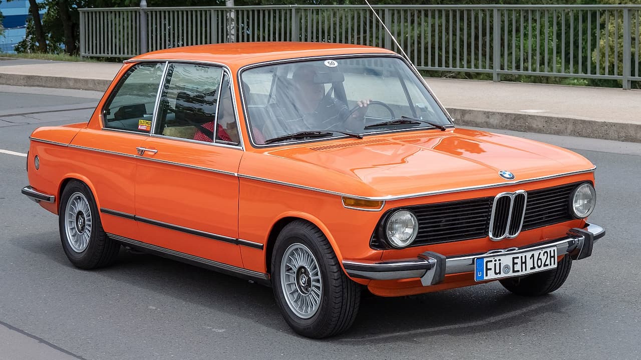 Orange BMW 1602 with distinctive kidney grille and German license plate parked on street