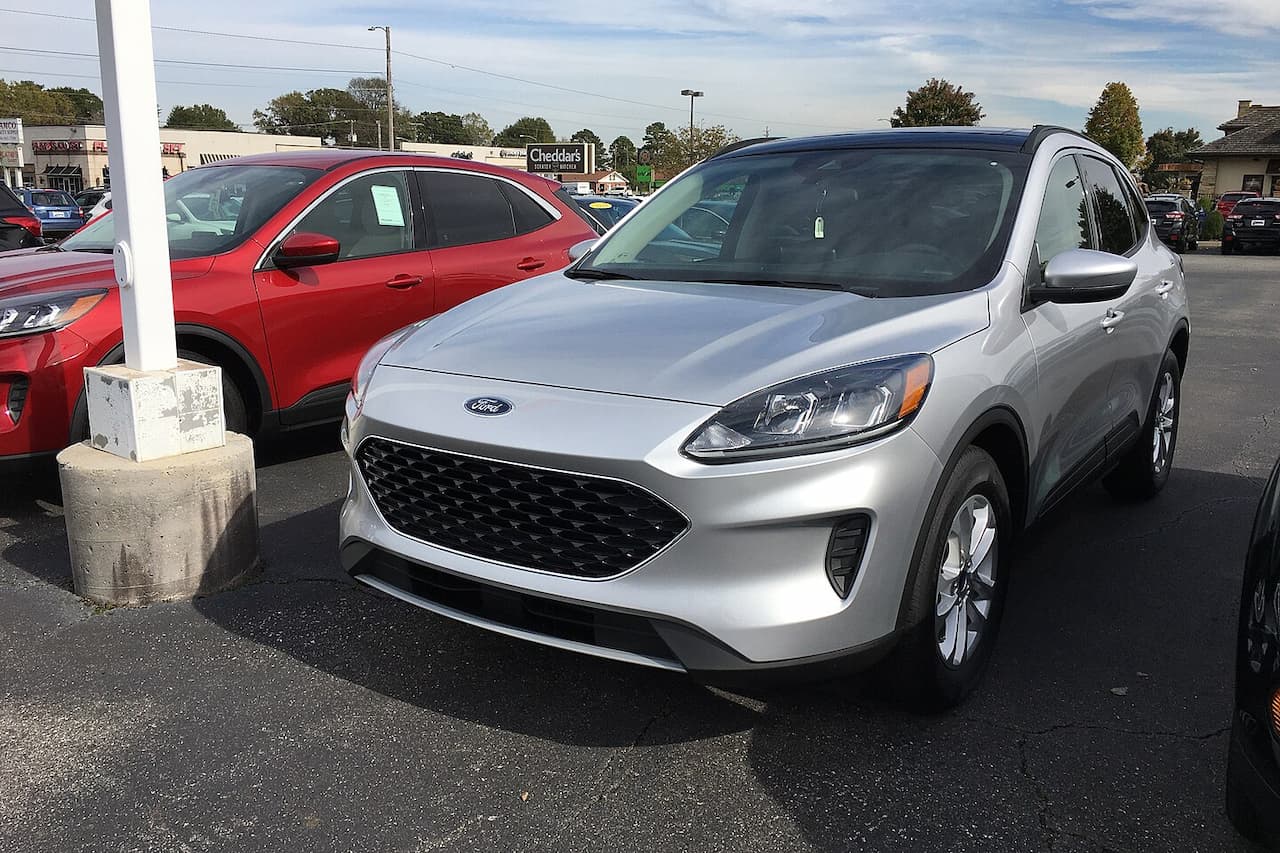Silver 2020 Ford Escape parked in dealership lot with black mesh grille, alloy wheels, and modern crossover design