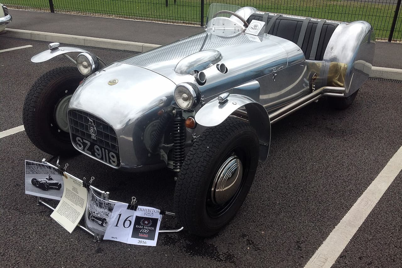 Silver Lotus Mark VI with lightweight chassis displayed at car show, featuring exposed suspension and wire wheels