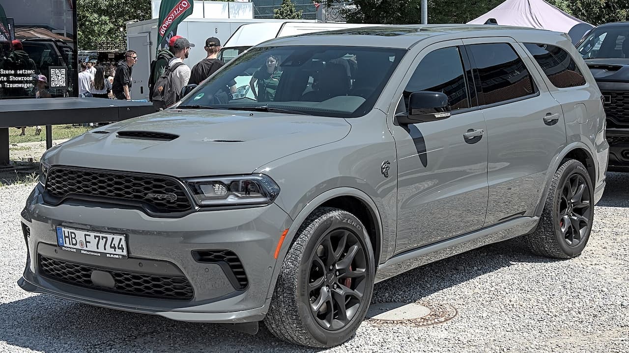 Gray Dodge Durango Hellcat parked at car event with German license plate and people gathered in background