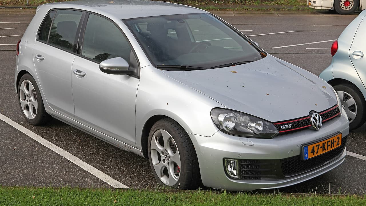 Silver 2009 Volkswagen Golf GTI with red GTI grille badge parked in parking lot with Dutch license plate