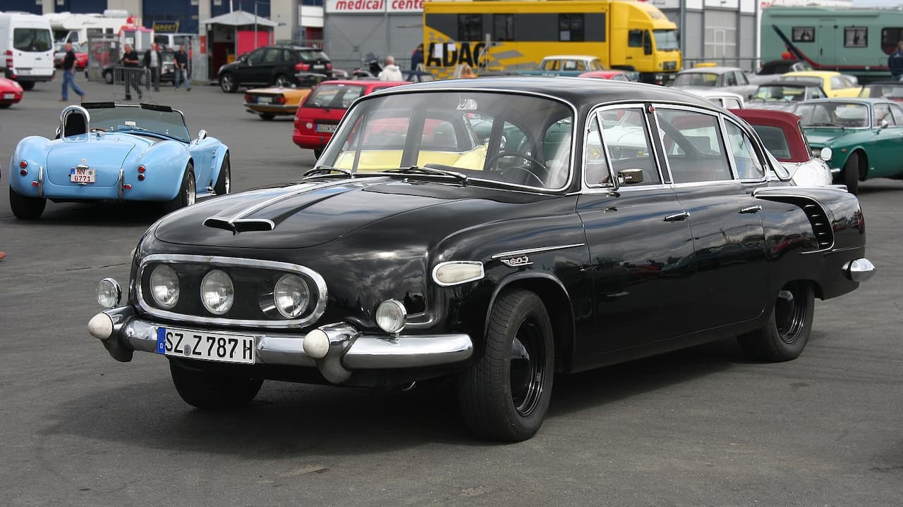Black Tatra 603 with distinctive triple headlights and German license plate at classic car gathering